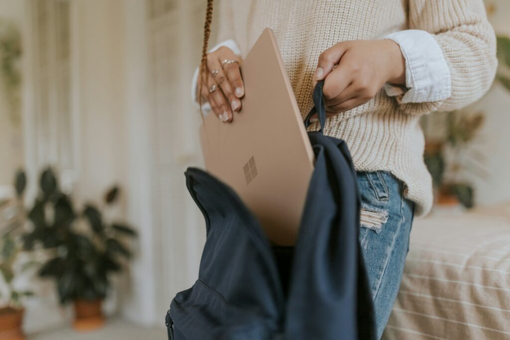 femme en jean bleu tenant un ordinateur portable à surface en grès