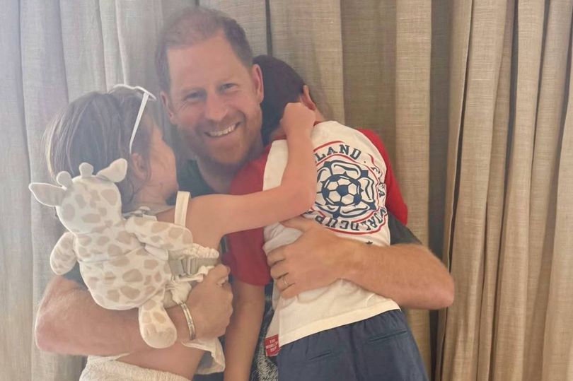 Prince Harry hugging Princess Lilibet and Prince Archie