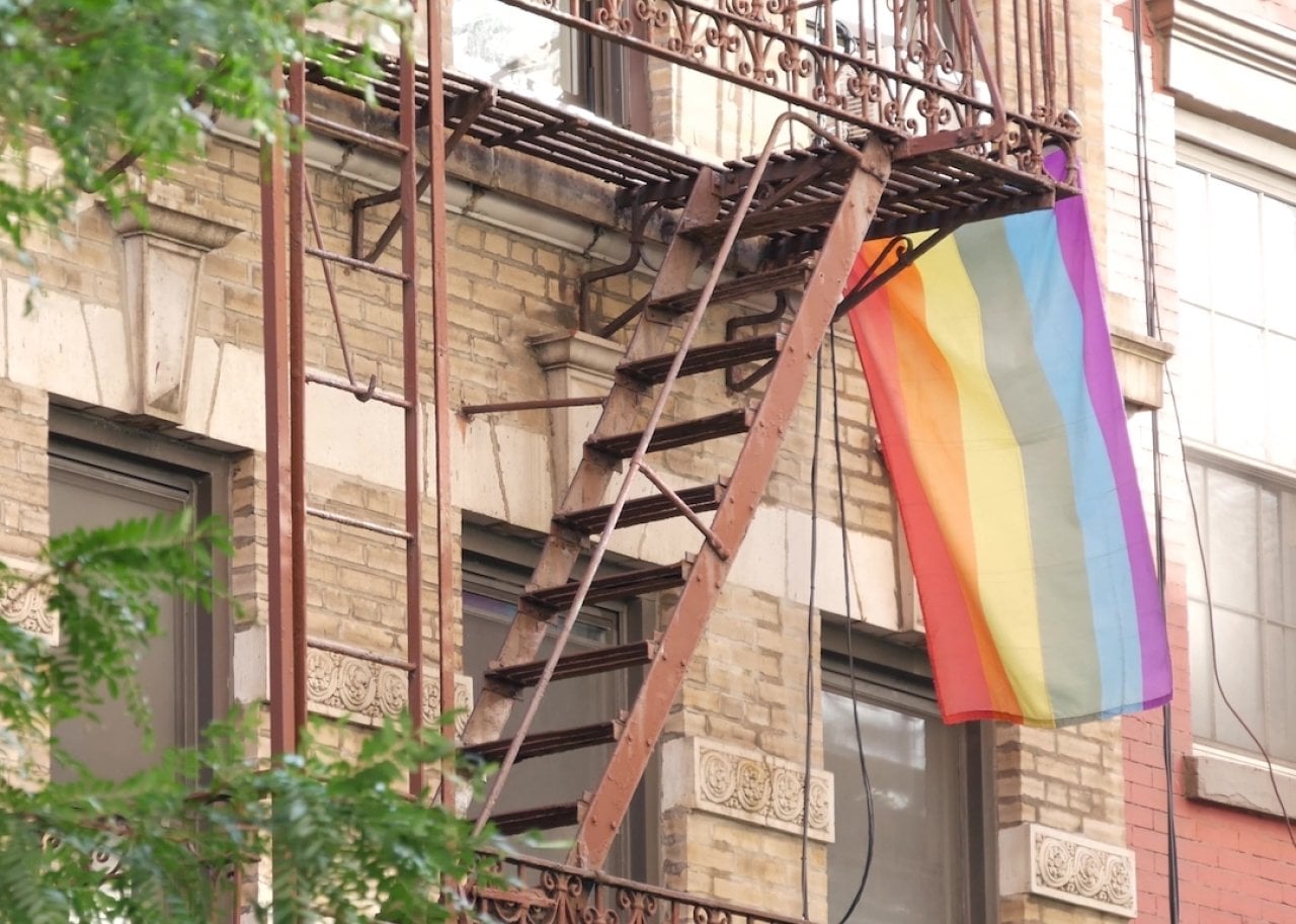 A rainbow flag flying outside of an apartment building in Manhattan, New York. -