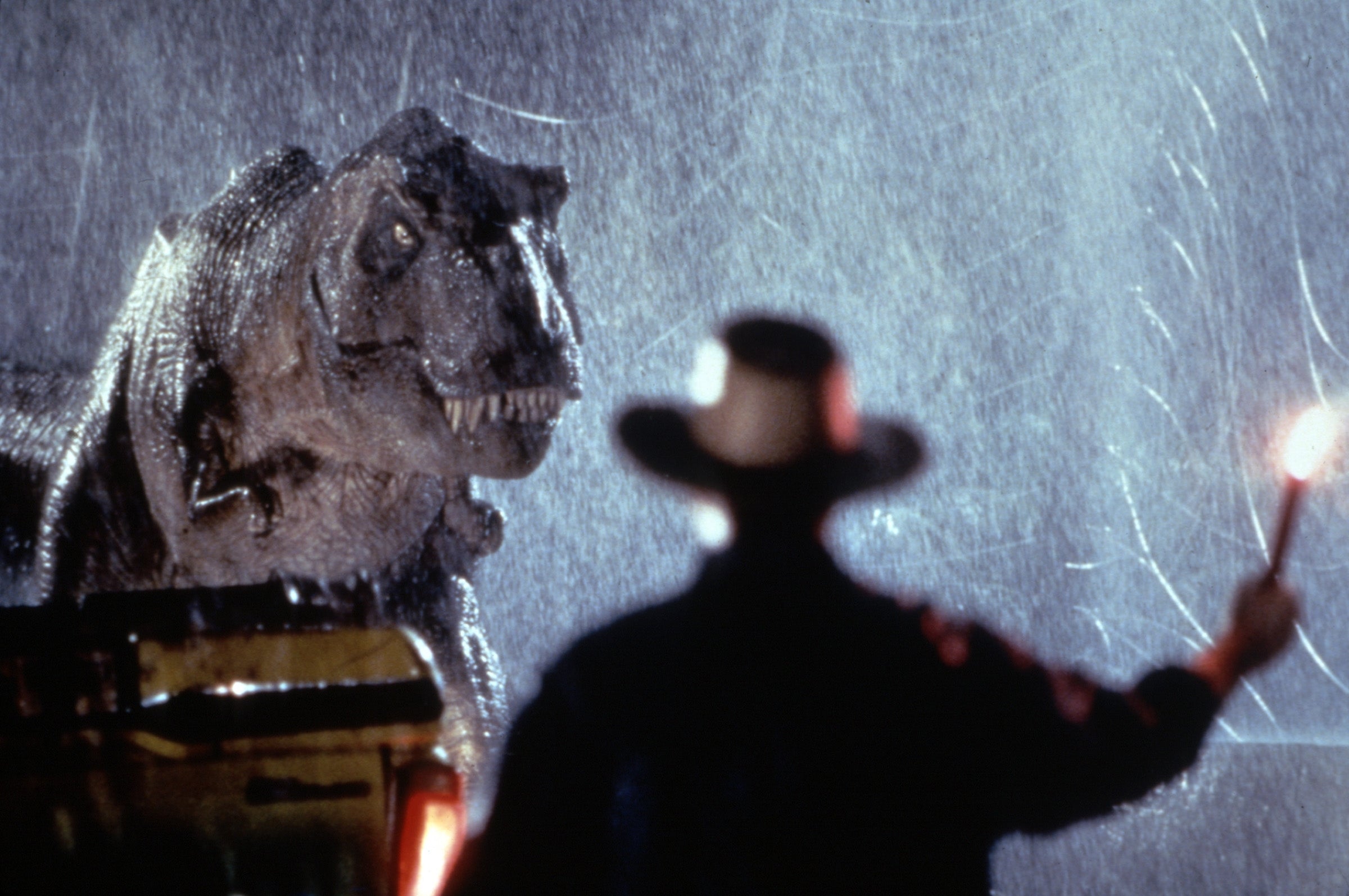 A person waving a flare at a T. rex in "Jurassic Park"