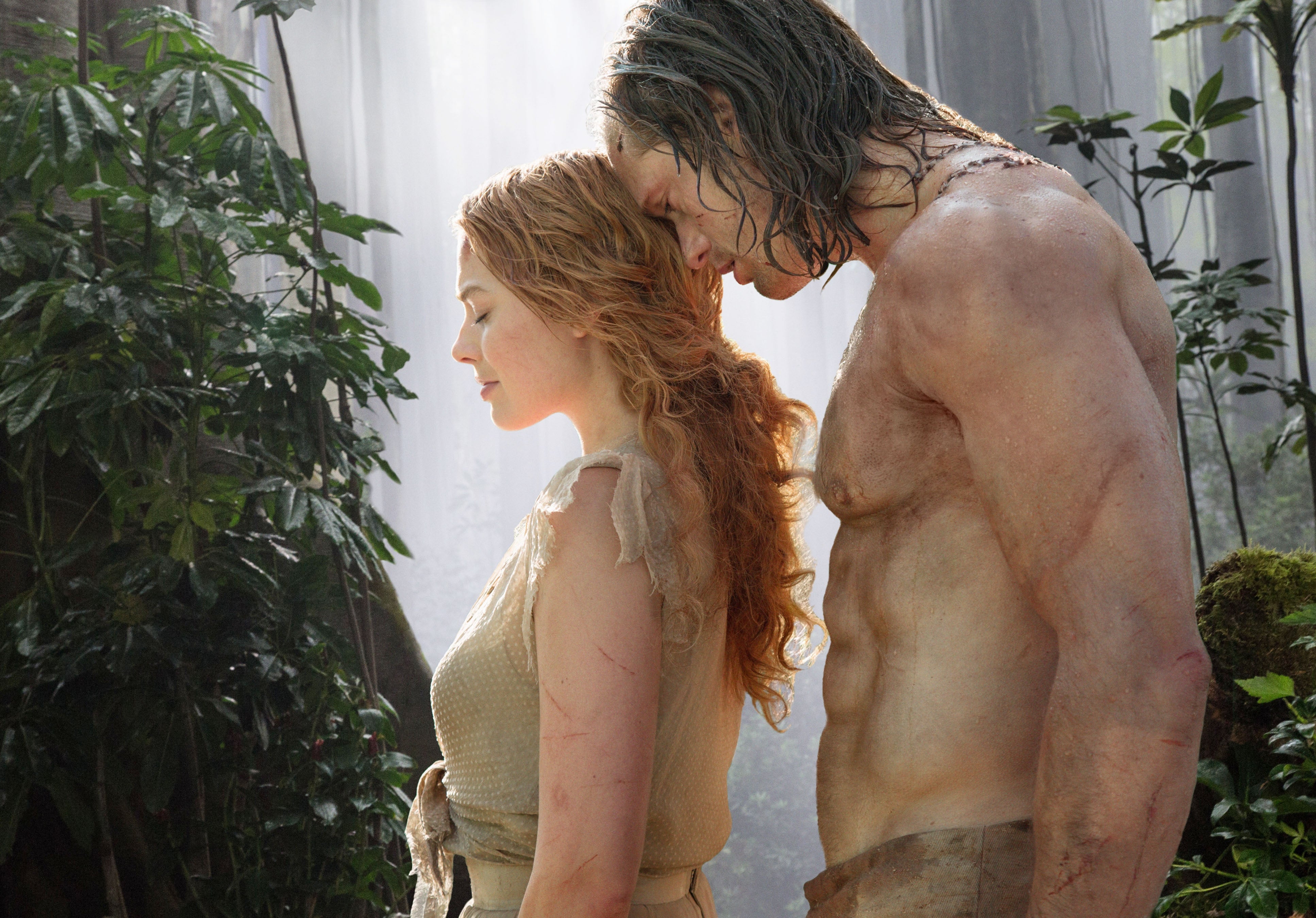 Margot Robbie and Alexander Skarsgard in a jungle scene standing closely next to each other