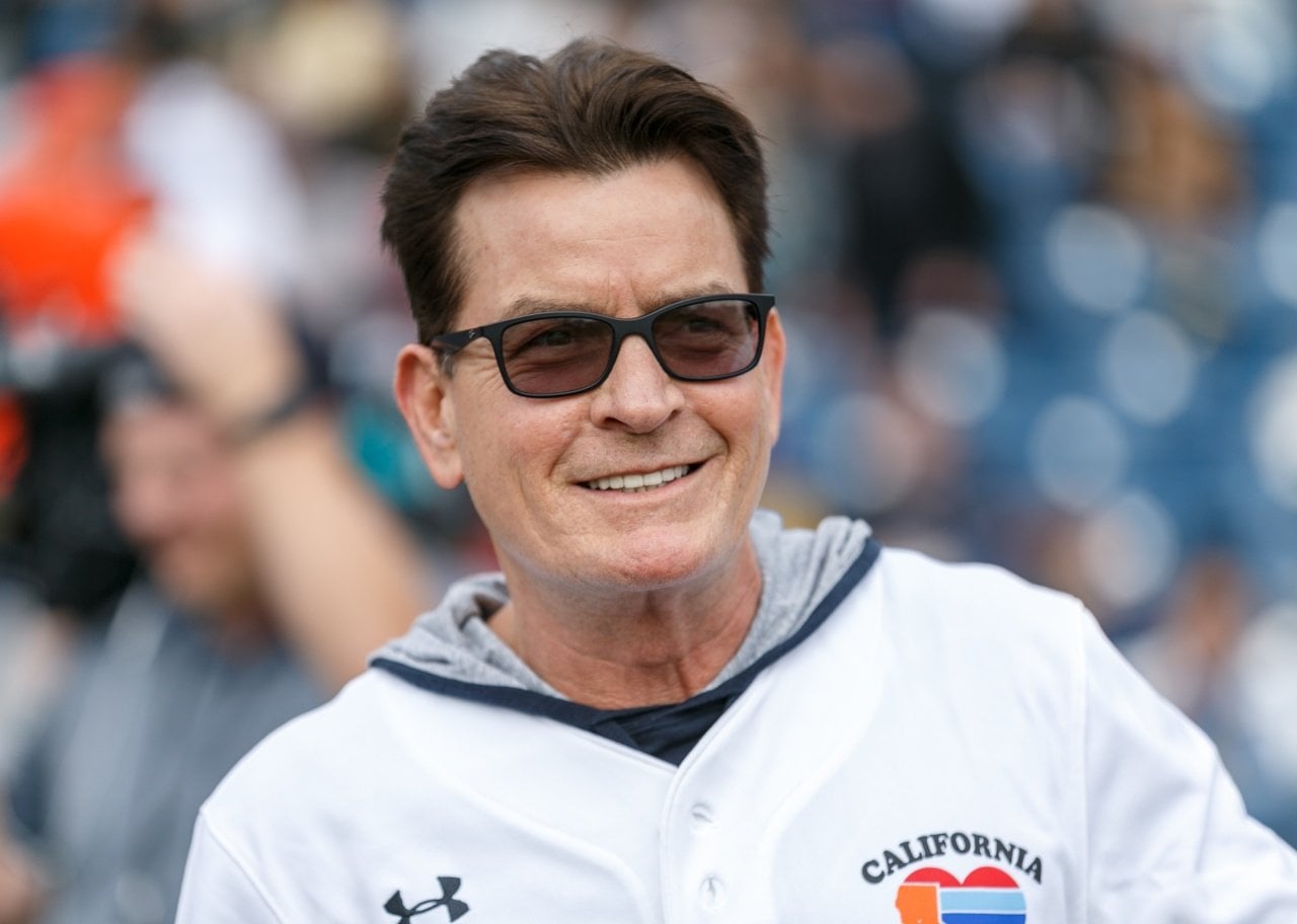 Charlie Sheen wearing a softball jersey at a game. - 