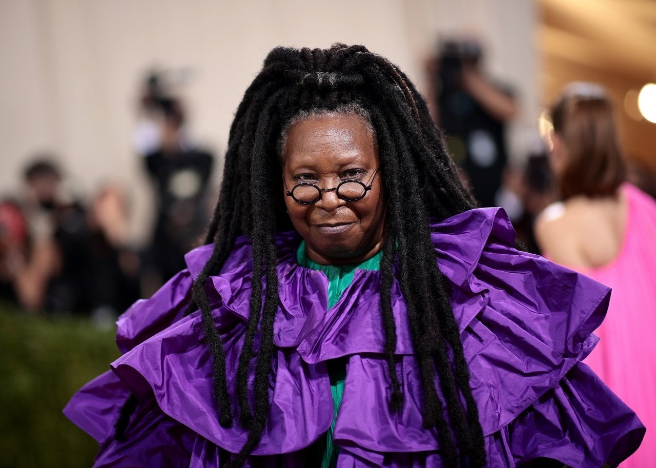 Whoopi Goldberg in a fluffy purple gown. - 