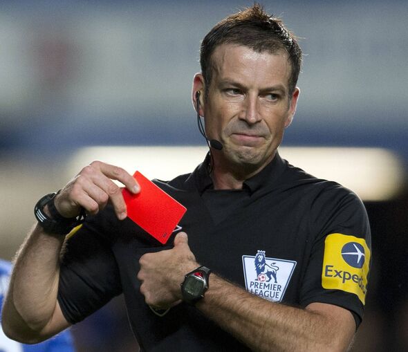 Mark Clattenburg holds a red card