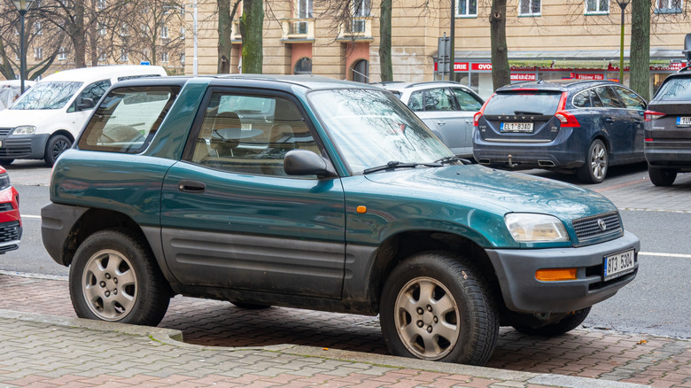 Bočni pogled na zelenu Toyotu RAV4 prve generacije parkiranu na gradskoj ulici.