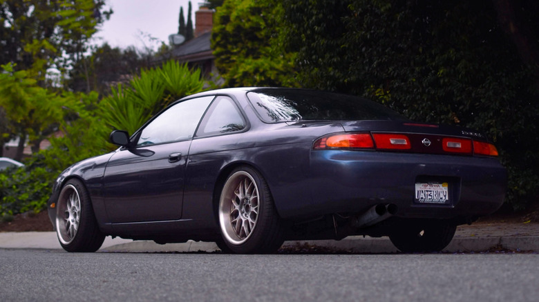 Stražnji 3/4 pogled na S14 Nissan 240SX parkiran na ulici.