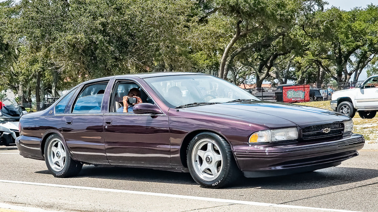 Pogled sprijeda 3/4 na ljubičasti Chevy Impala iz 1996. na sajmu automobila.