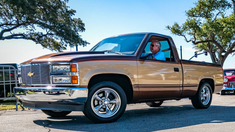 Prednji 3/4 pogled na zlatni Chevy Silverado OBS kamionet na sajmu automobila.