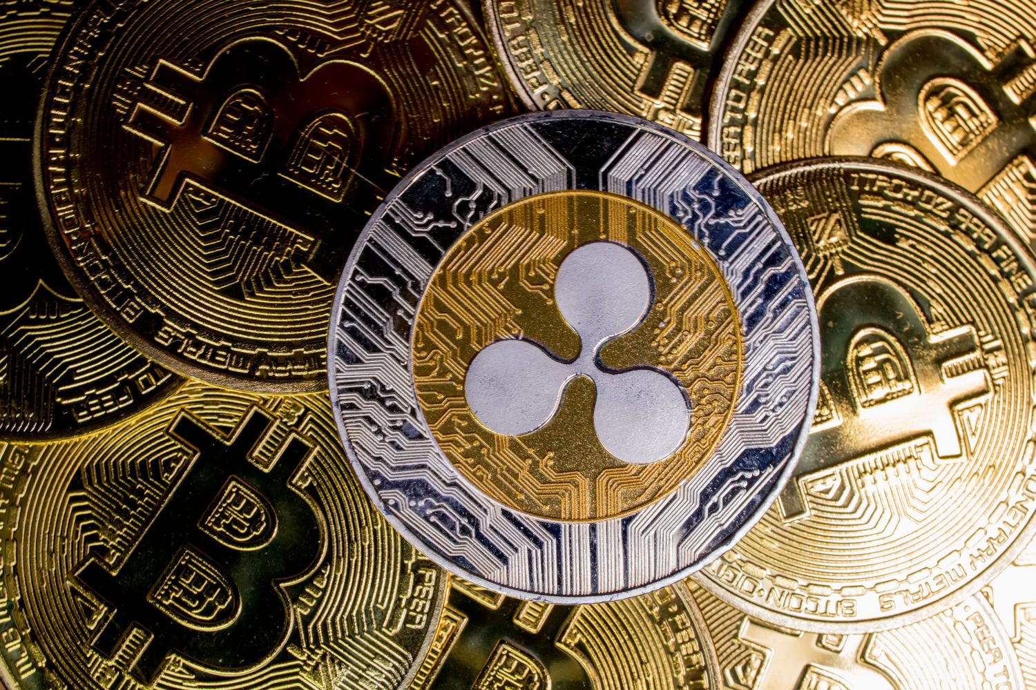Ripple XRP coin on bitcoins background, cryptocurrency investing concept.