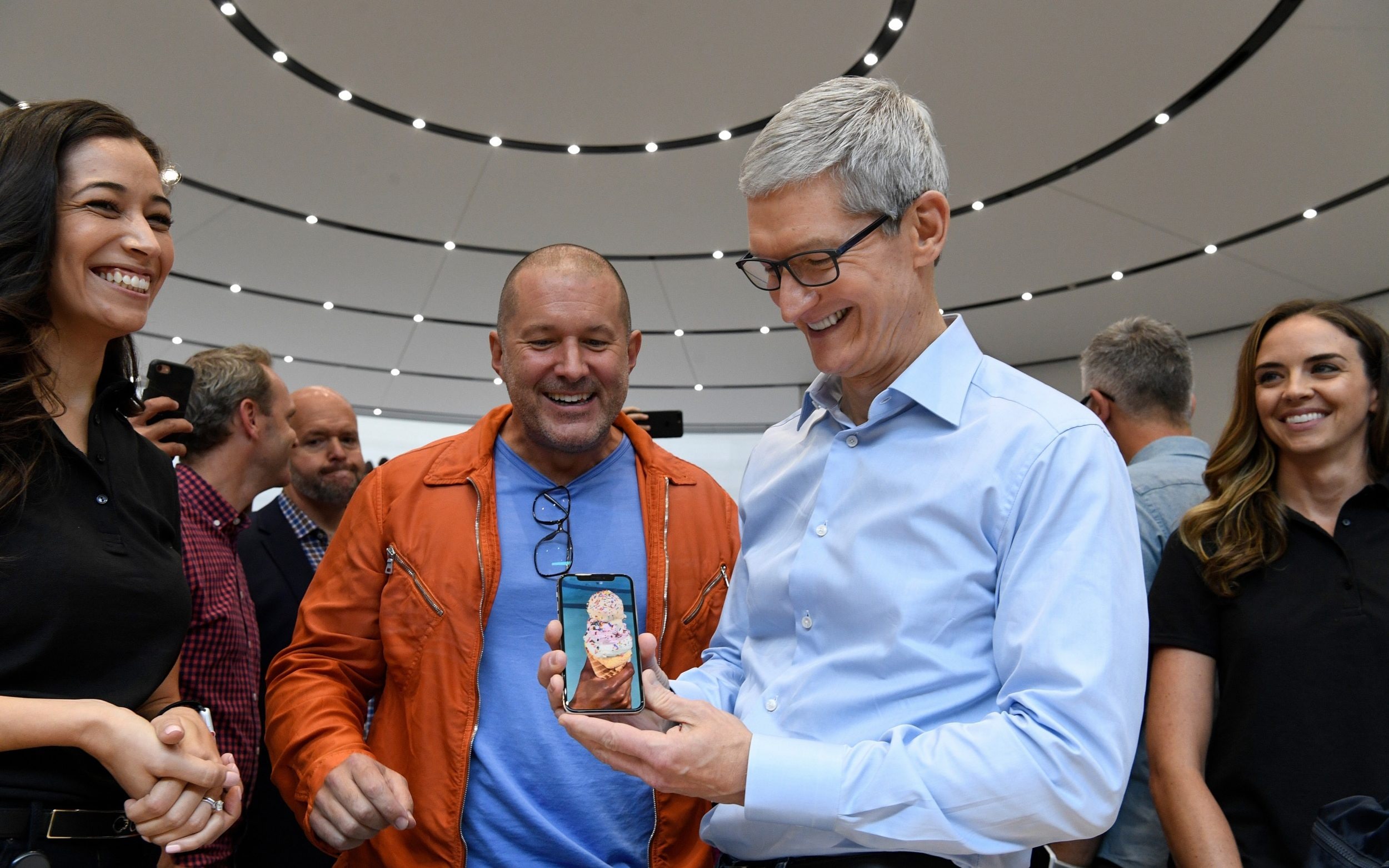 Jony Ive and Tim Cook, who is holding an iPhone