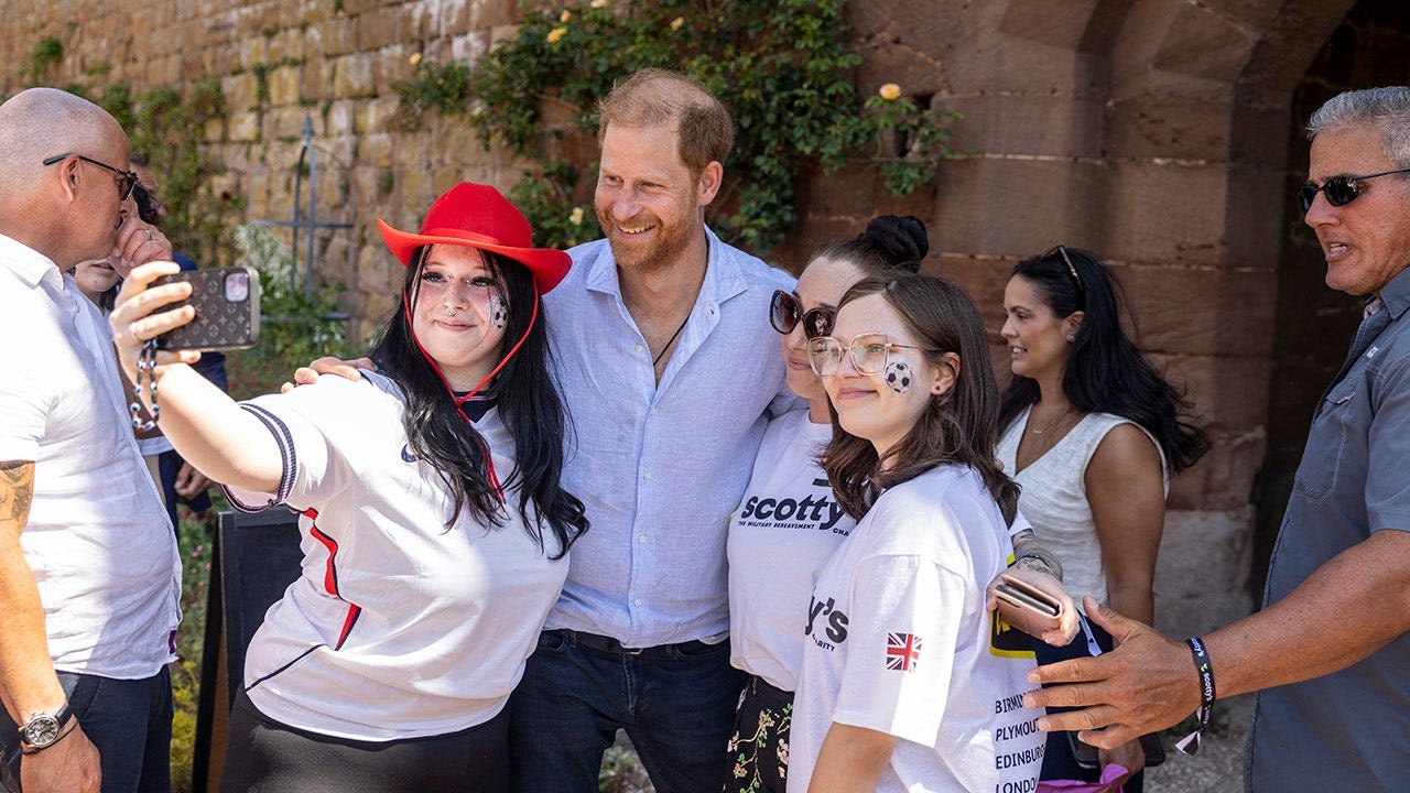 El príncipe Harry posa para una selfie con sus simpatizantes en el castillo de Maxstoke.