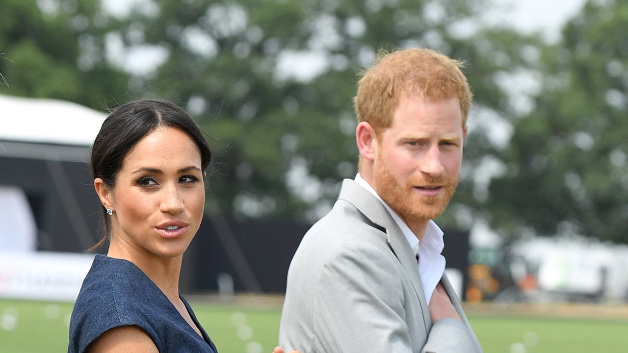 Meghan Markle luce un vestido azul junto al príncipe Harry con abrigo caqui