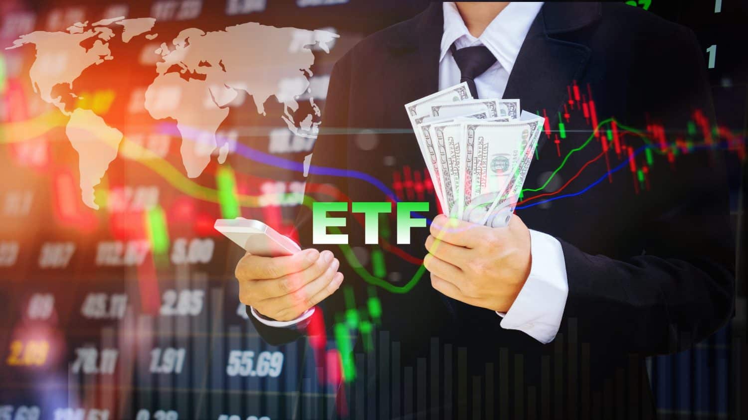 A person in a dark suit and white shirt holds a white smartphone in their left hand and a fan of US dollar bills in their right hand. The green letters 'ETF' are superimposed over their torso. The background is a blurred, glowing financial display showing a white world map, colorful stock charts with red and green candlesticks, line graphs (red, green, blue), and numerical data.