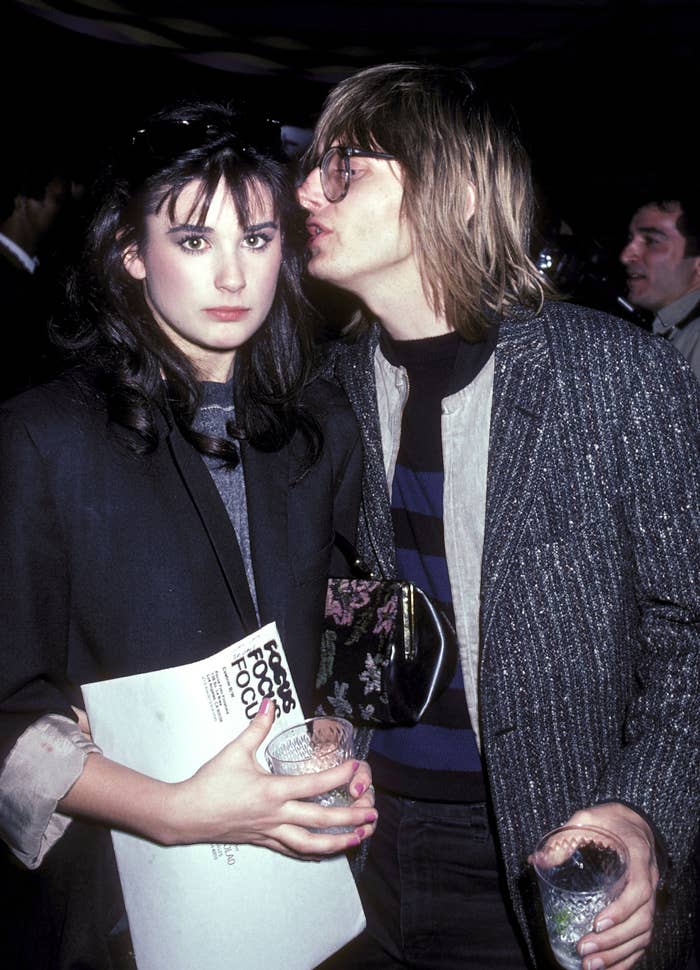 Demi Moore wears a black blazer and looks pensive as Freddy Moore kisses her cheek while holding a drink