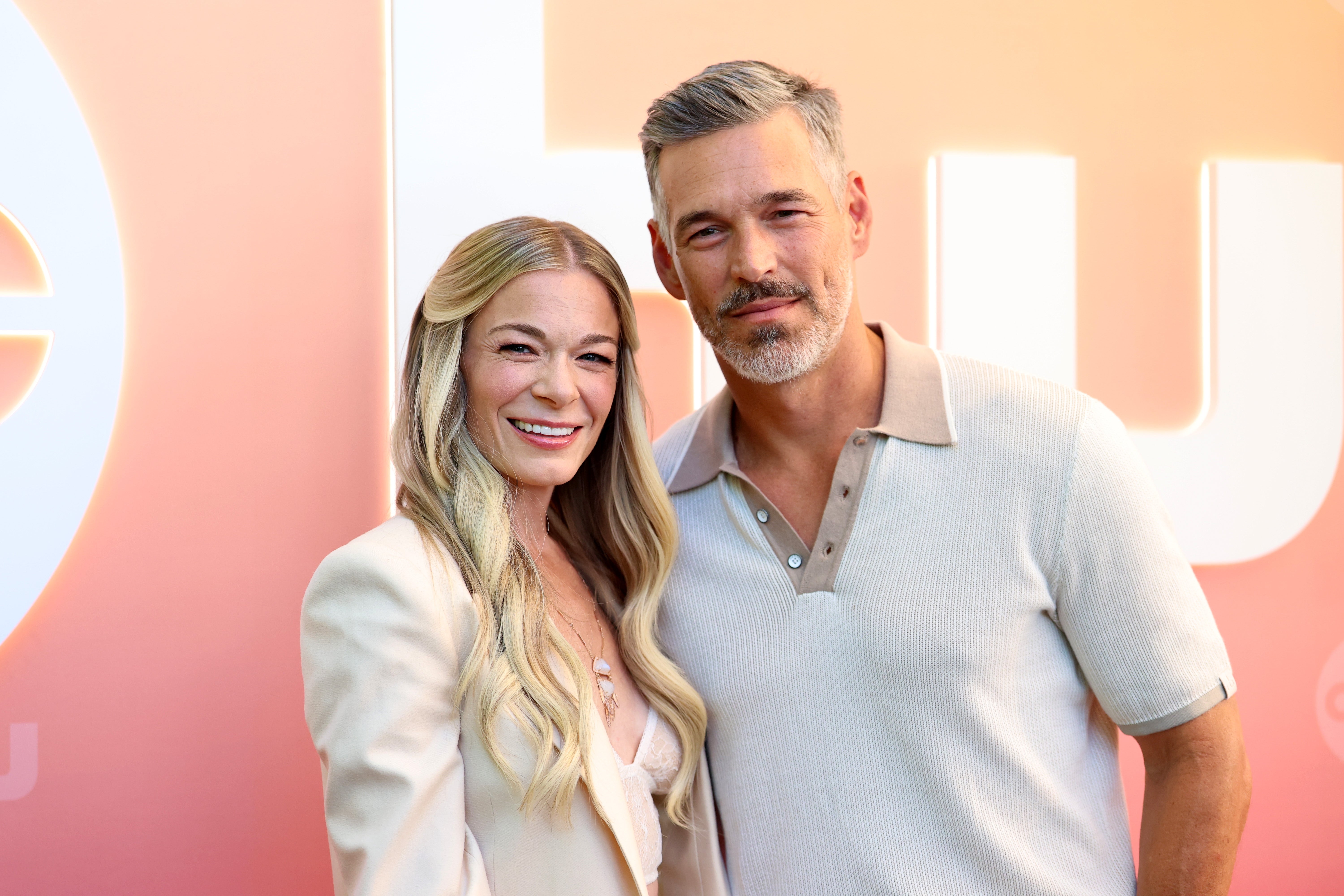 LeAnn Rimes and Eddie Cibrian pose together at an event, smiling warmly