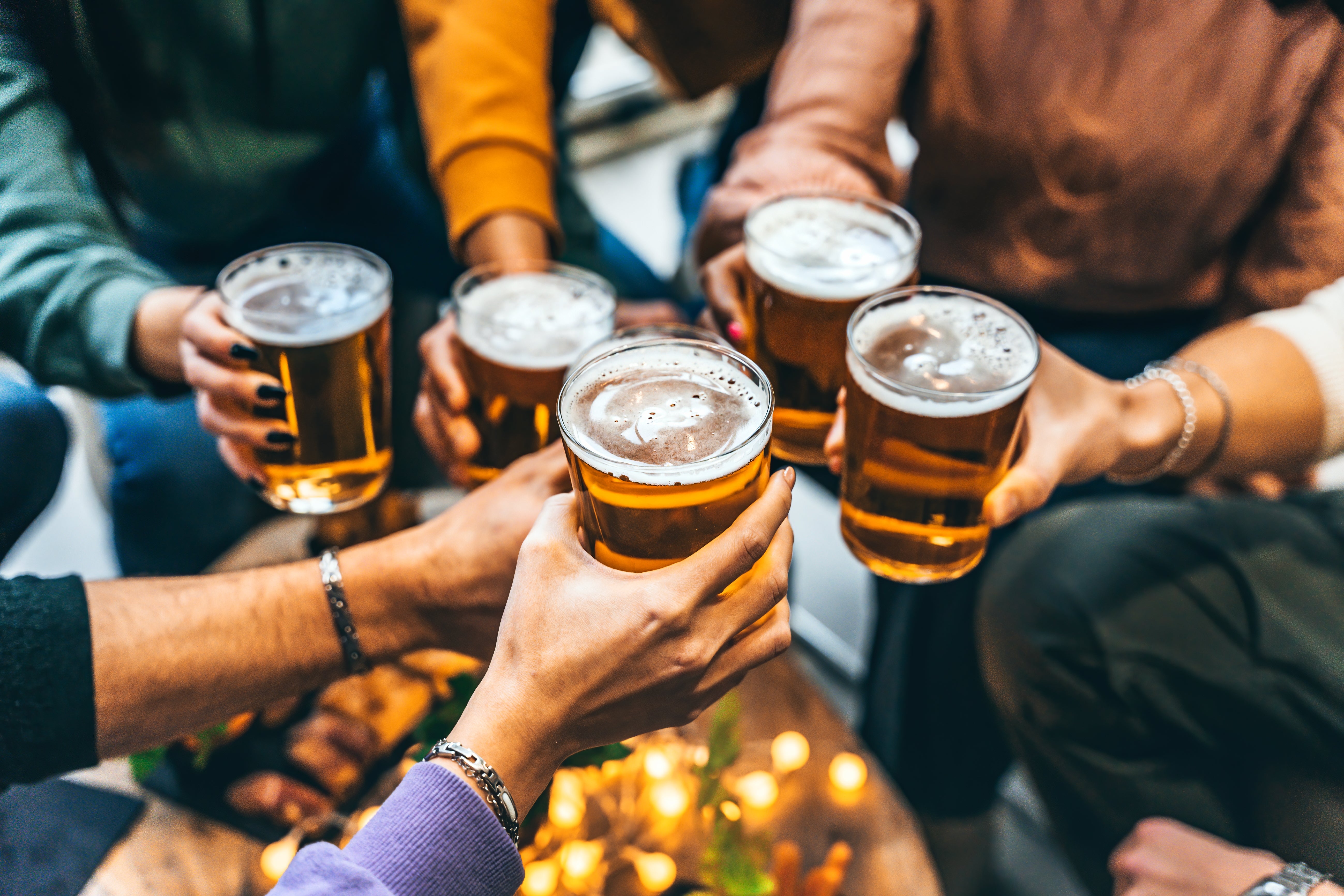 A group of people raising glasses of beer for a toast
