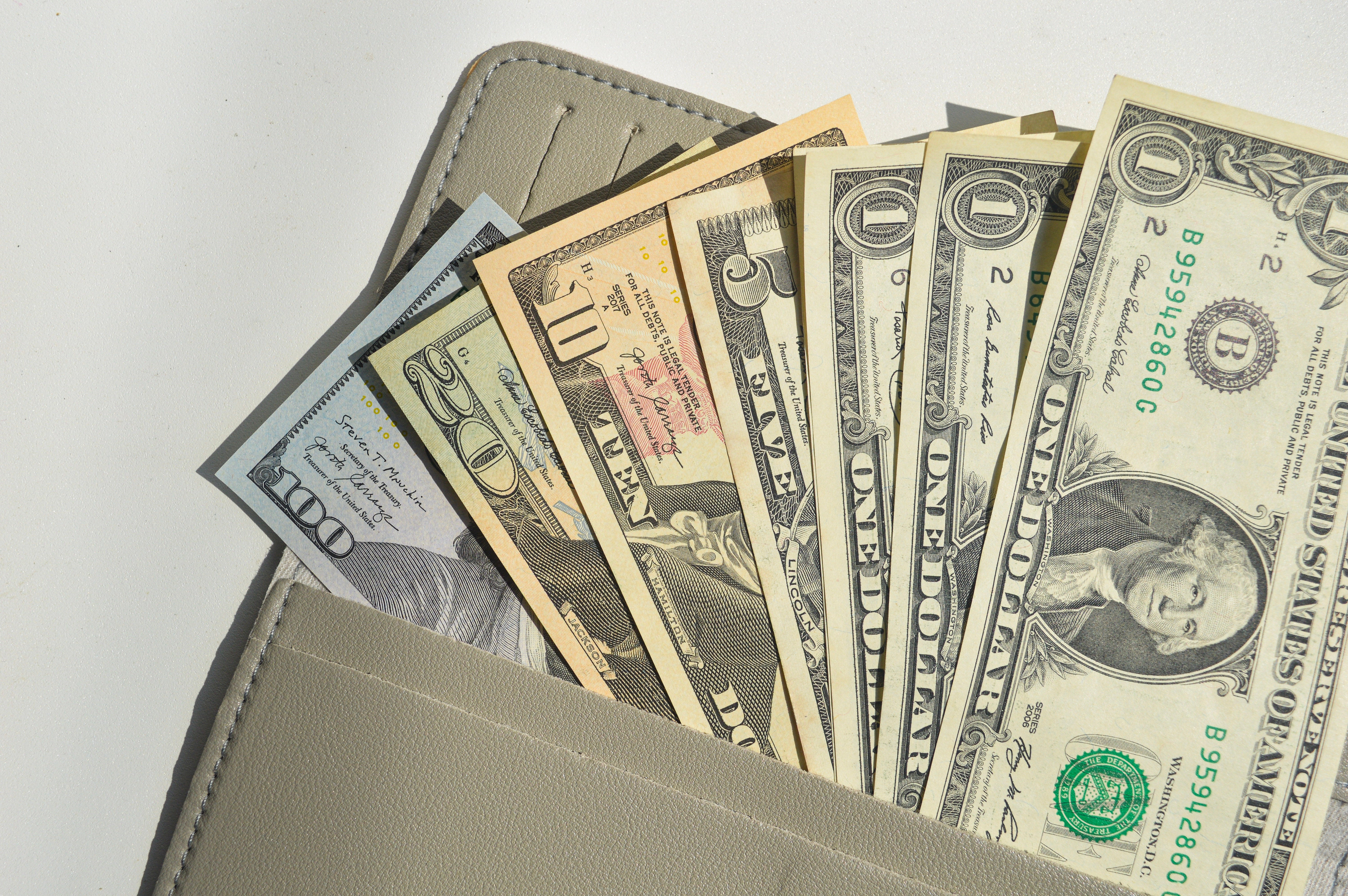 A wallet with various dollar bills sticking out