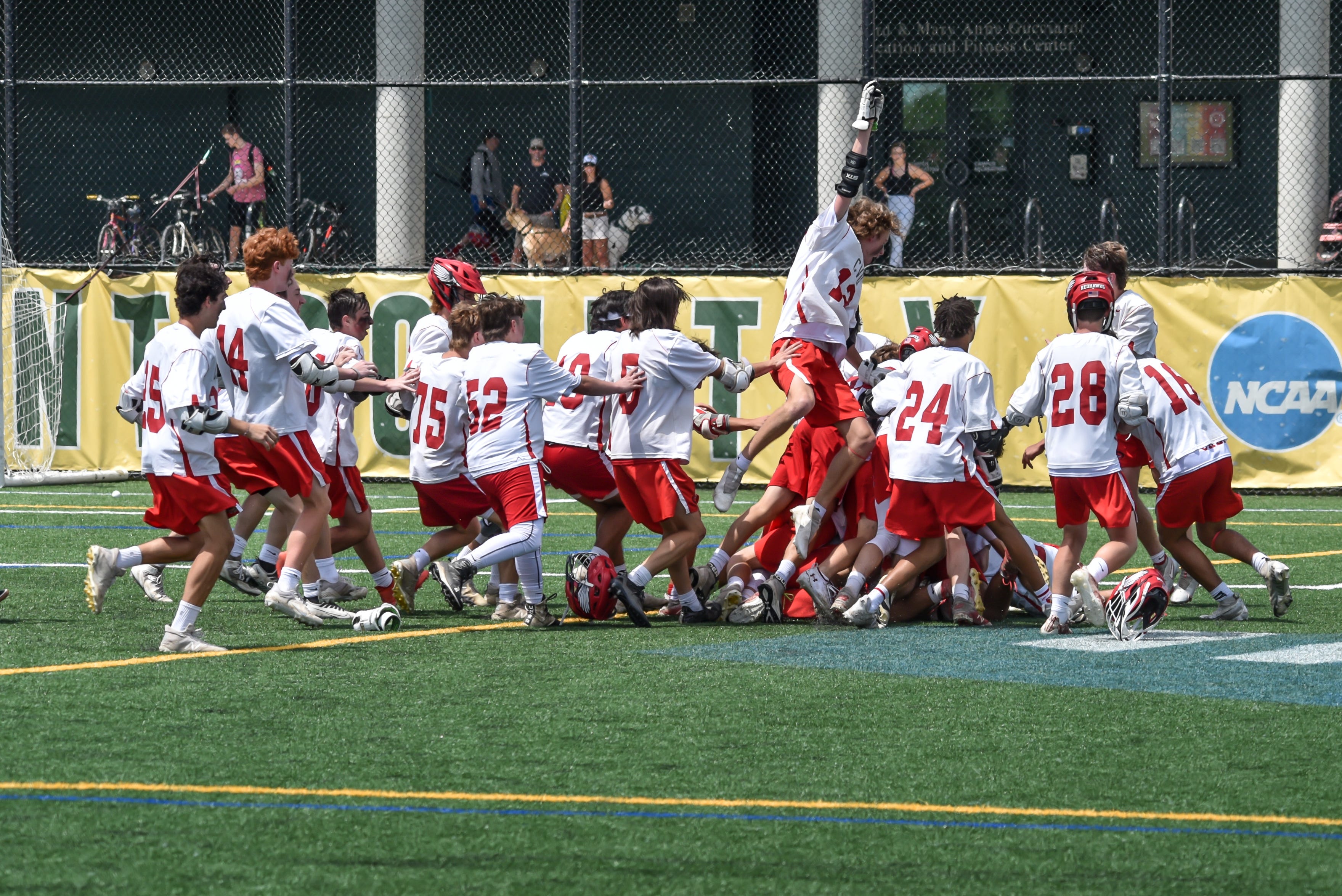 The CVU Redhawks celebrate their hard fought 13-11 D1Boys Lacrosse Championship win over the Burr and Burton Bulldogs on Saturday afternoon at UVM's Virtue Field