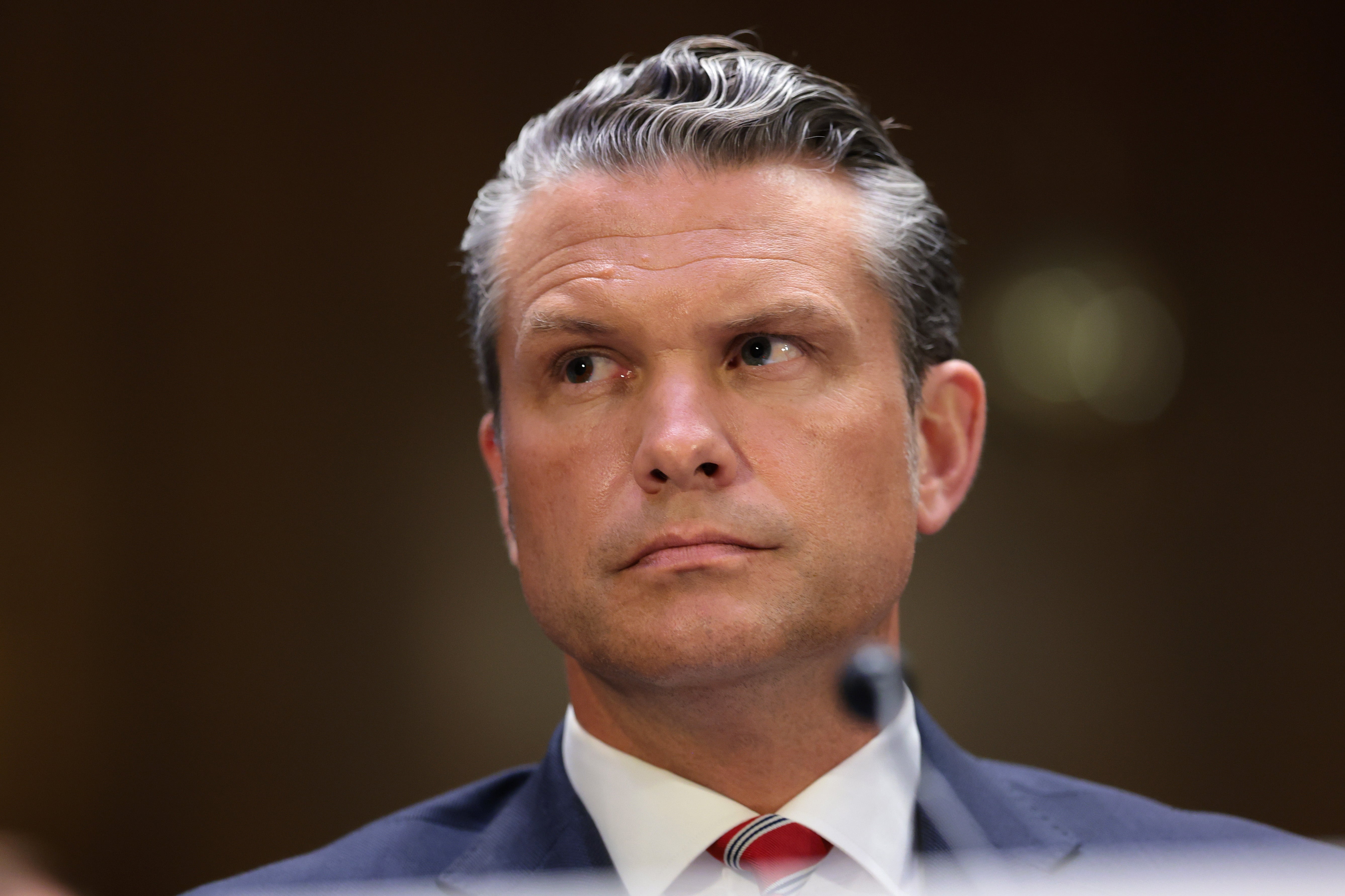Man attending an event, wearing a suit and tie, looking slightly to the side