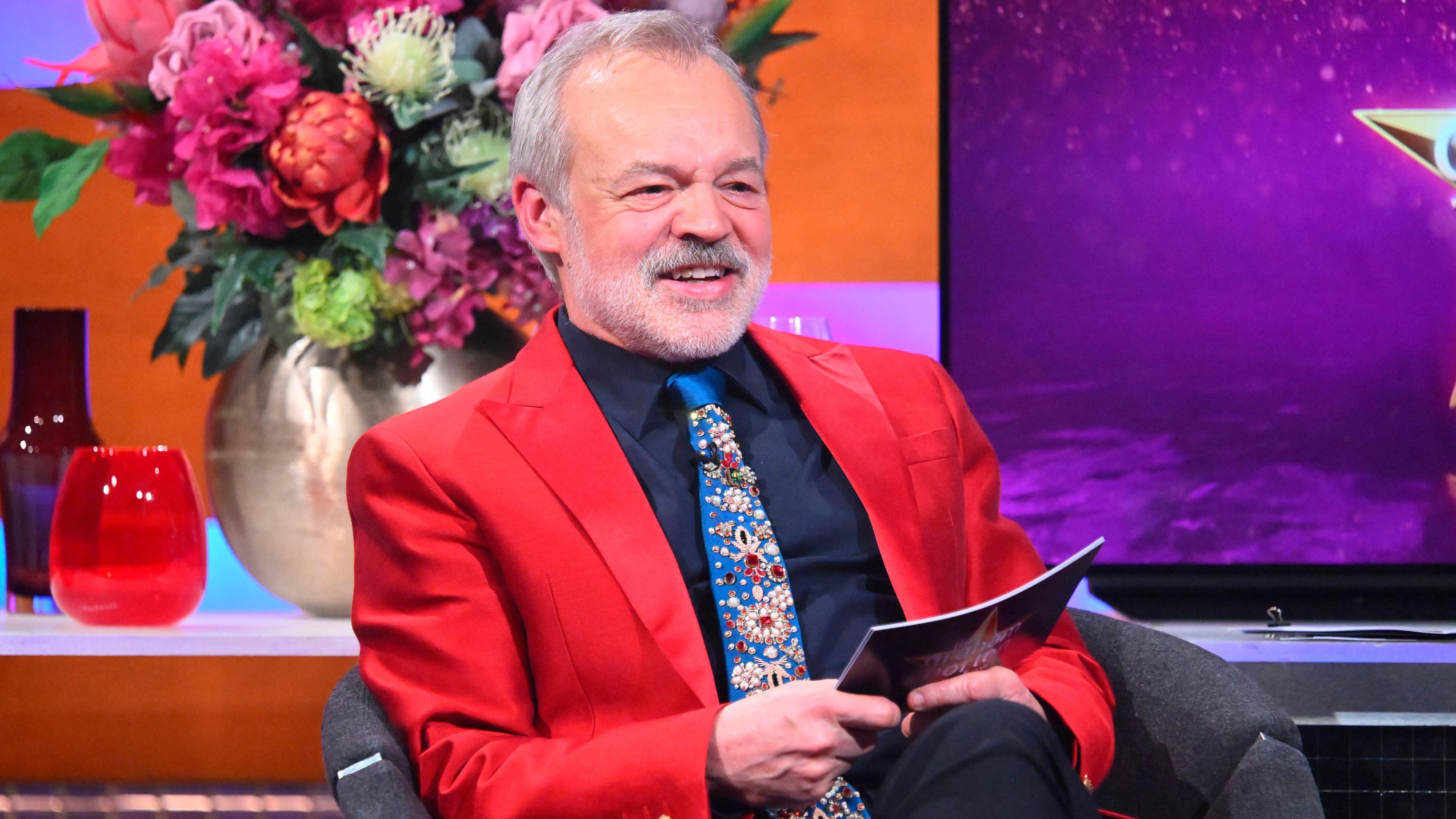Graham Norton seen on the set of the Graham Norton Show, wearing a bright red blazer