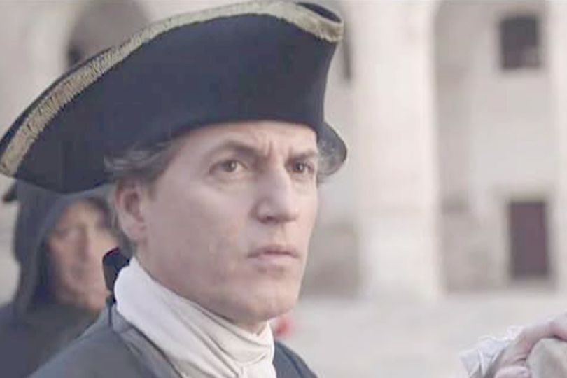 A man in a hat looks serious