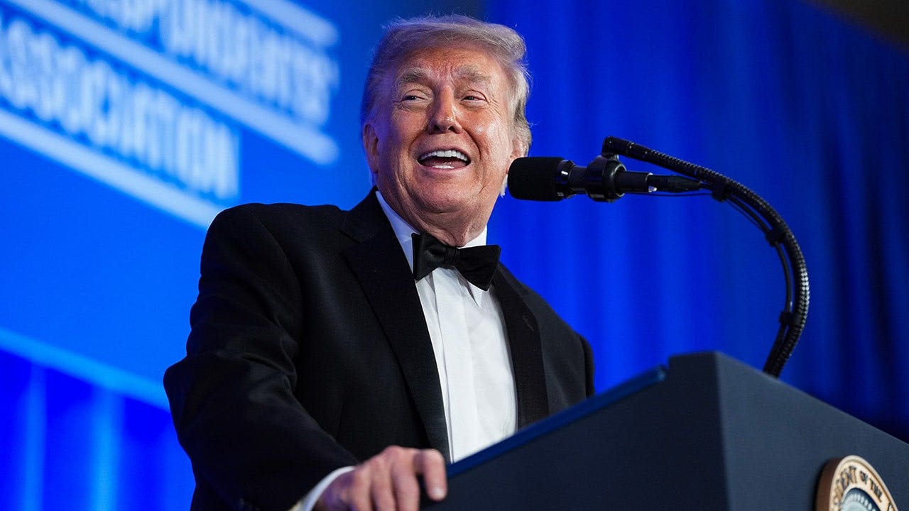 Donald Trump speaks at a podium during the White House Correspondents' Dinner.