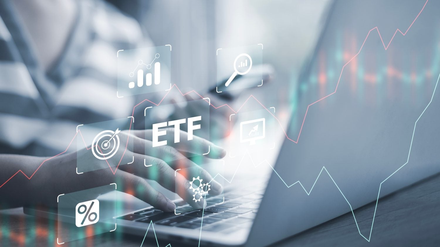 A close-up shot of a person's hands typing on a laptop keyboard, set against a blurred background. Overlayed translucent white icons represent financial concepts: a bar chart, a magnifying glass with a chart, the text 'ETF', a computer monitor with an arrow, a target with an arrow, gears, and a percentage sign. Red and teal line graphs, resembling stock market charts, are also overlaid, suggesting financial data analysis.