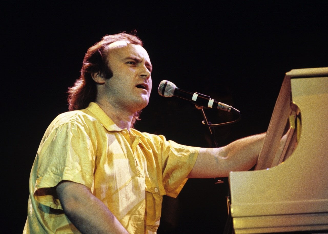 Phil Collins behind a piano. - 