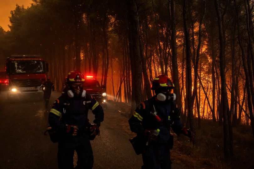 Greek firefighters try to extinguish a blaze in the area of Porto Germeno, some 70 kilometres (45 miles) northwest of Athens