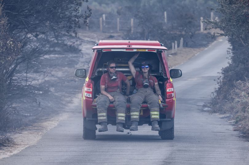 Two fire service workers, covered in soot, being driven away from the site in Suffolk
