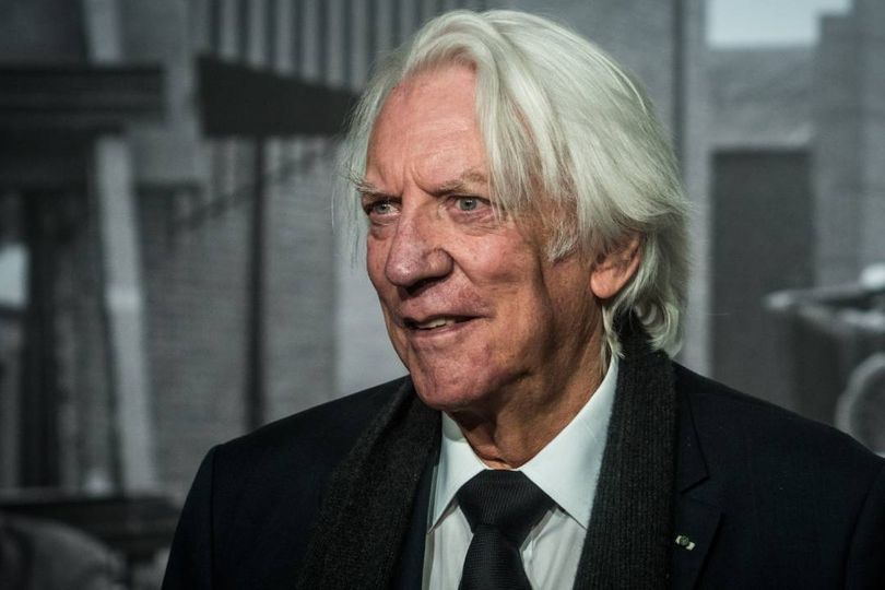 Grey haired man in black suit
