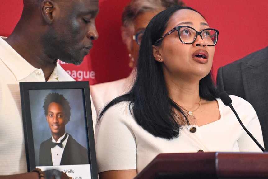 Christine Wonsley speaks as Elmore Wonsley, left, stands at her side holding a pH๏τo of their deceased son, Nolan Wells, as they appear at the National Urban League's annual conference, Thursday, July 30, 2026, in Nashville, Tenn.