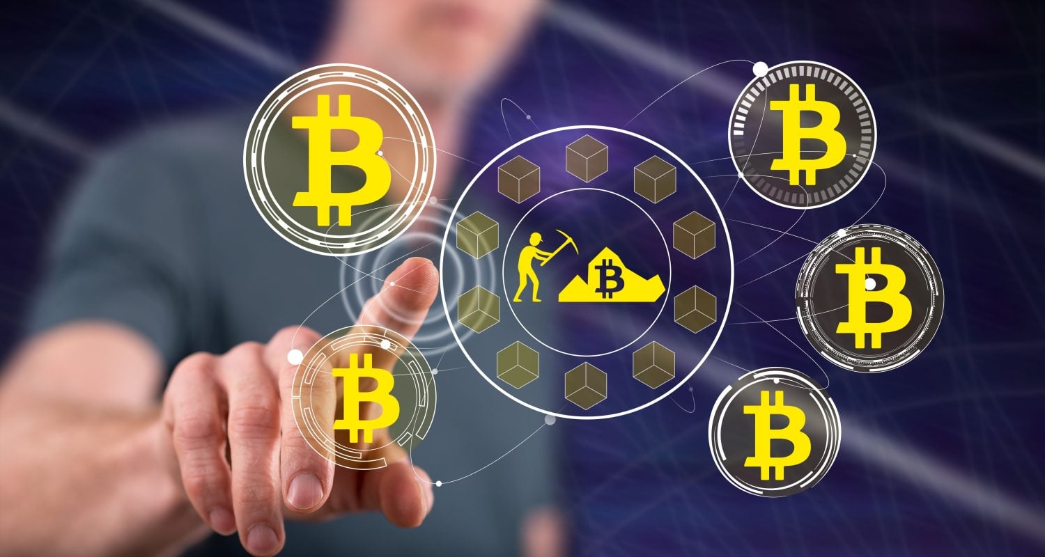 A person's finger points towards a central digital graphic depicting a miner with a pickaxe next to a pile of Bitcoin, surrounded by brown cubes. This central element is connected by white lines to multiple glowing circular icons, each containing a yellow Bitcoin symbol on a dark background, all set against a blurred dark blue backdrop.