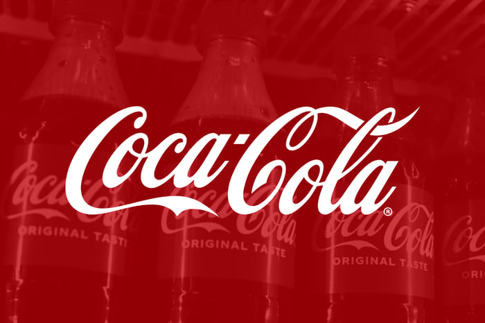 Coca-Cola logo on red filter with bottles in background.