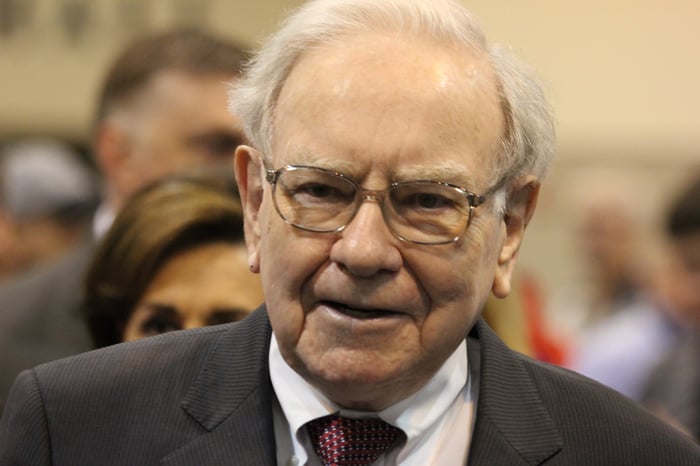 Warren Buffett surrounded by people at Berkshire Hathaway