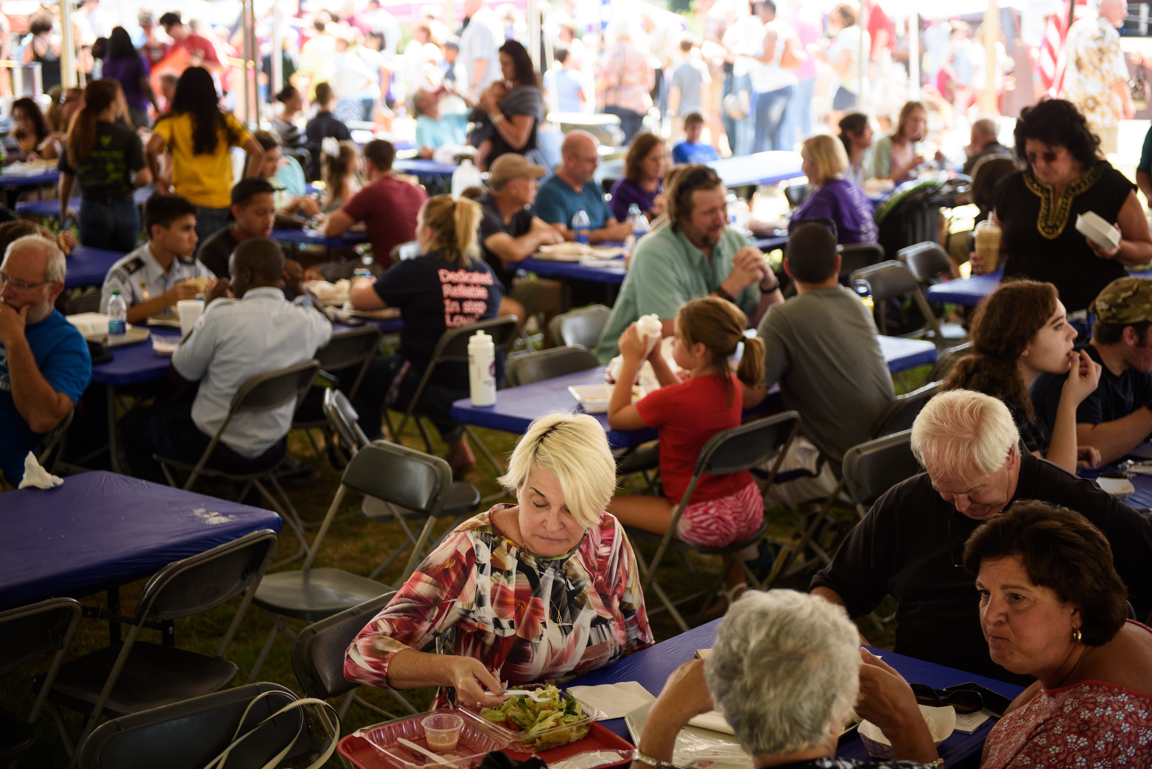 People sit in the shade and eat at the Greek Festival on Saturday, Sept. 9, 2017.