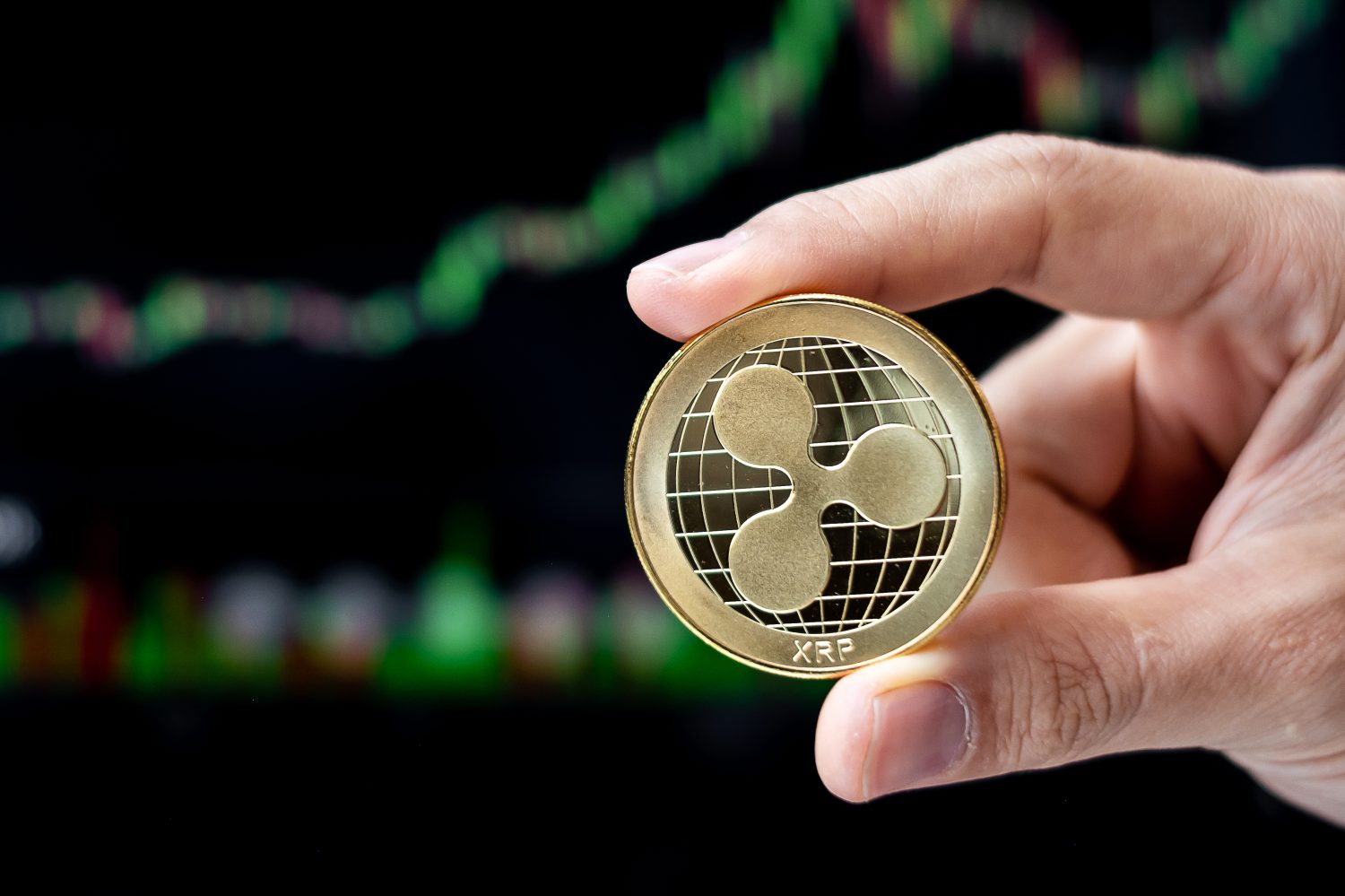 Golden Ripple (XRP) cryptocurrency coin with candle graph background, Crypto is Digital Money within the blockchain network, is using technology and online internet exchange.