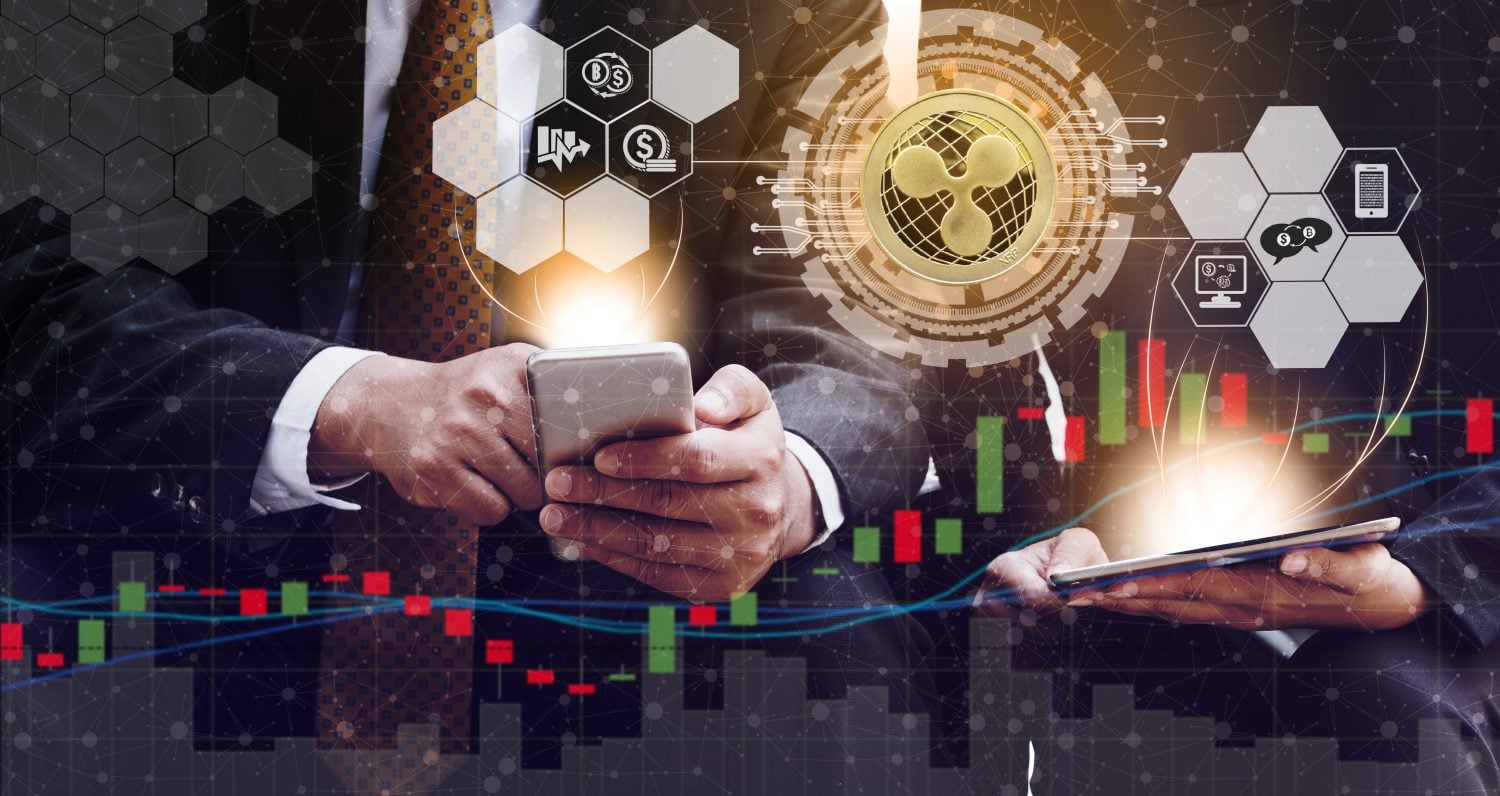 Ripple and cryptocurrency investing concept - Businessman using mobile phone application to trade Ripple XRP with another trader in modern graphic interface. Blockchain and financial technology.
