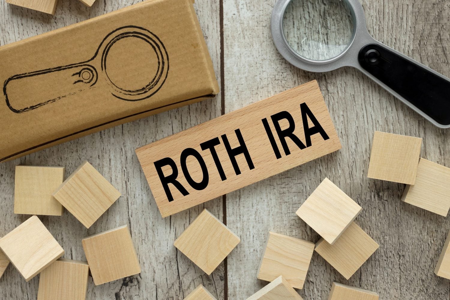 ROTH IRA wooden block on a light table. magnifier and wooden cubes.