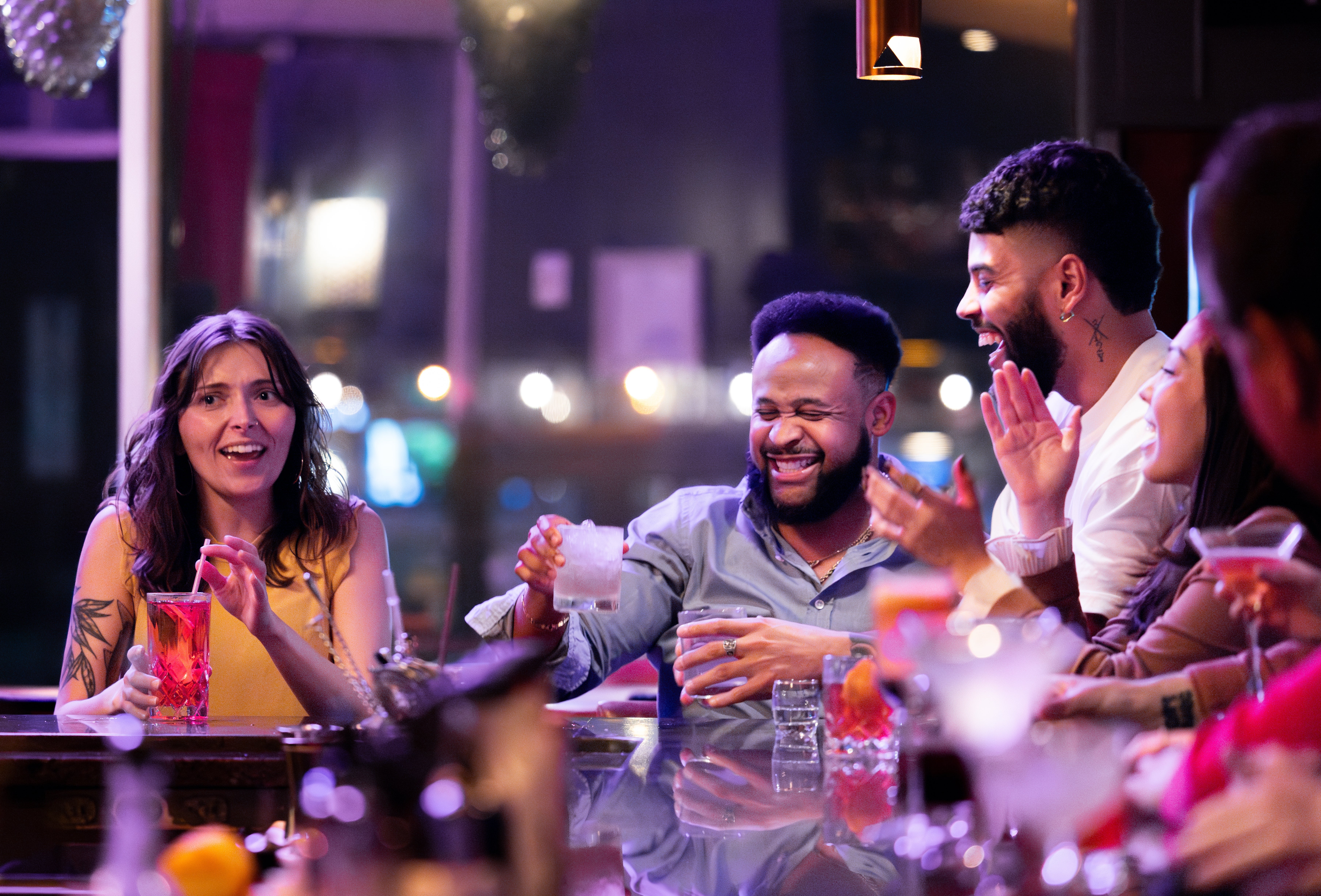 People at a lively bar enjoy drinks and conversation, highlighting a relaxed and social work-life balance setting