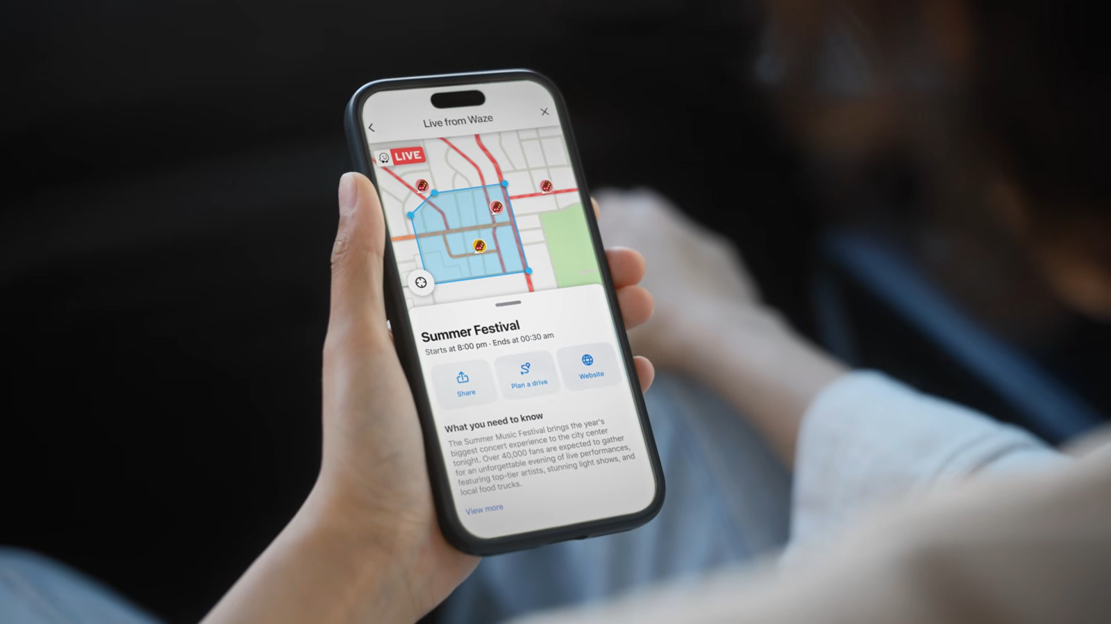 Hand holding phone showing Waze app