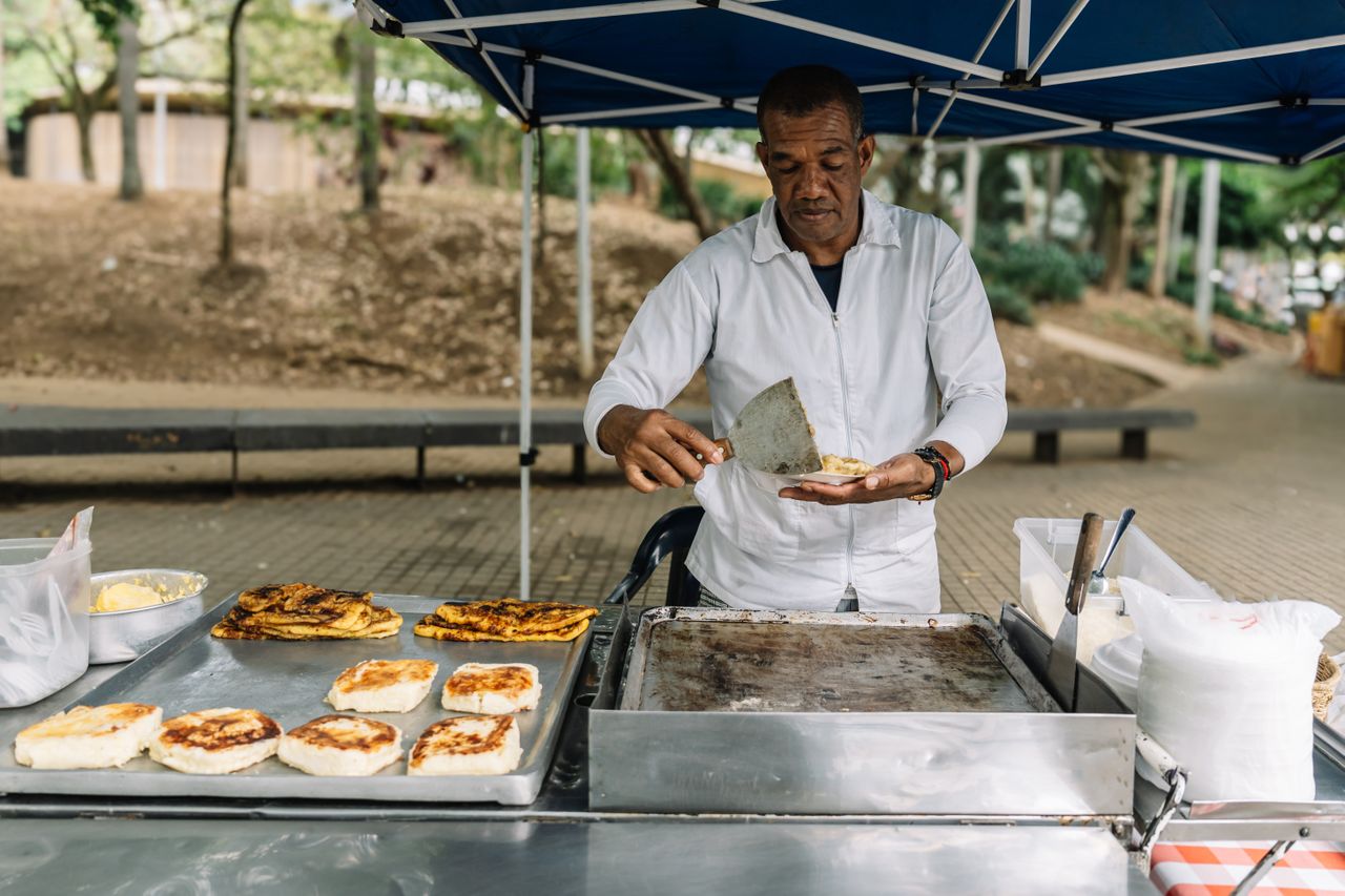 Cheese arepas and other popular foods from Medellín street vendors mean you can often grab meals out for less than making them at home.Credit: Helen Camacaro / Getty Images