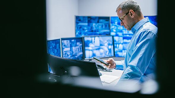 A man working at a computer with multiple monitors