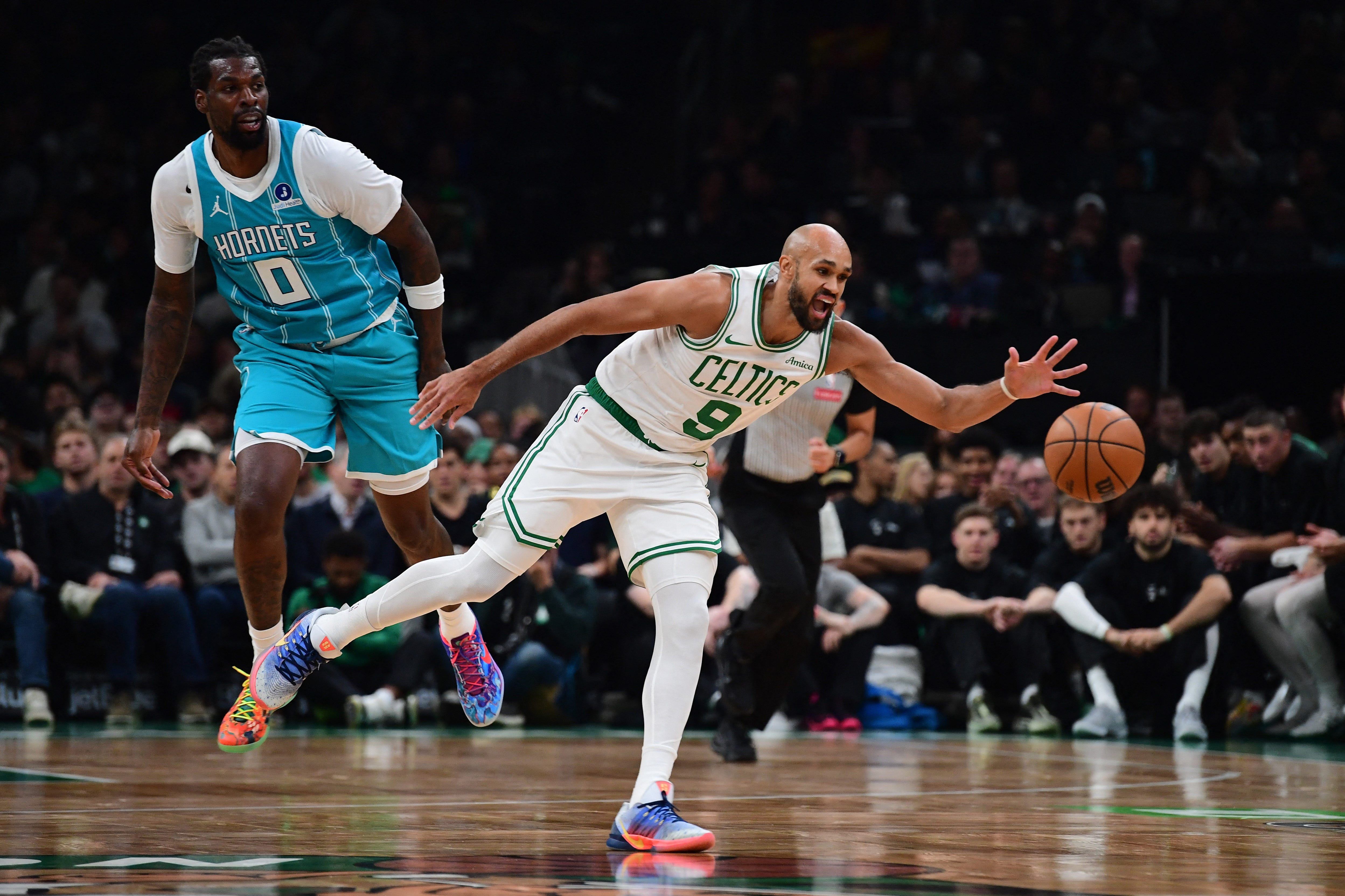 Oct 14, 2026; Boston, Massachusetts, USA;  Boston Celtics guard Derrick White (9) reaches for the ball while Charlotte Hornets center Naz Reid (0) looks on during the first half at TD Garden. Mandatory Credit: Bob DeChiara-Imagn Images