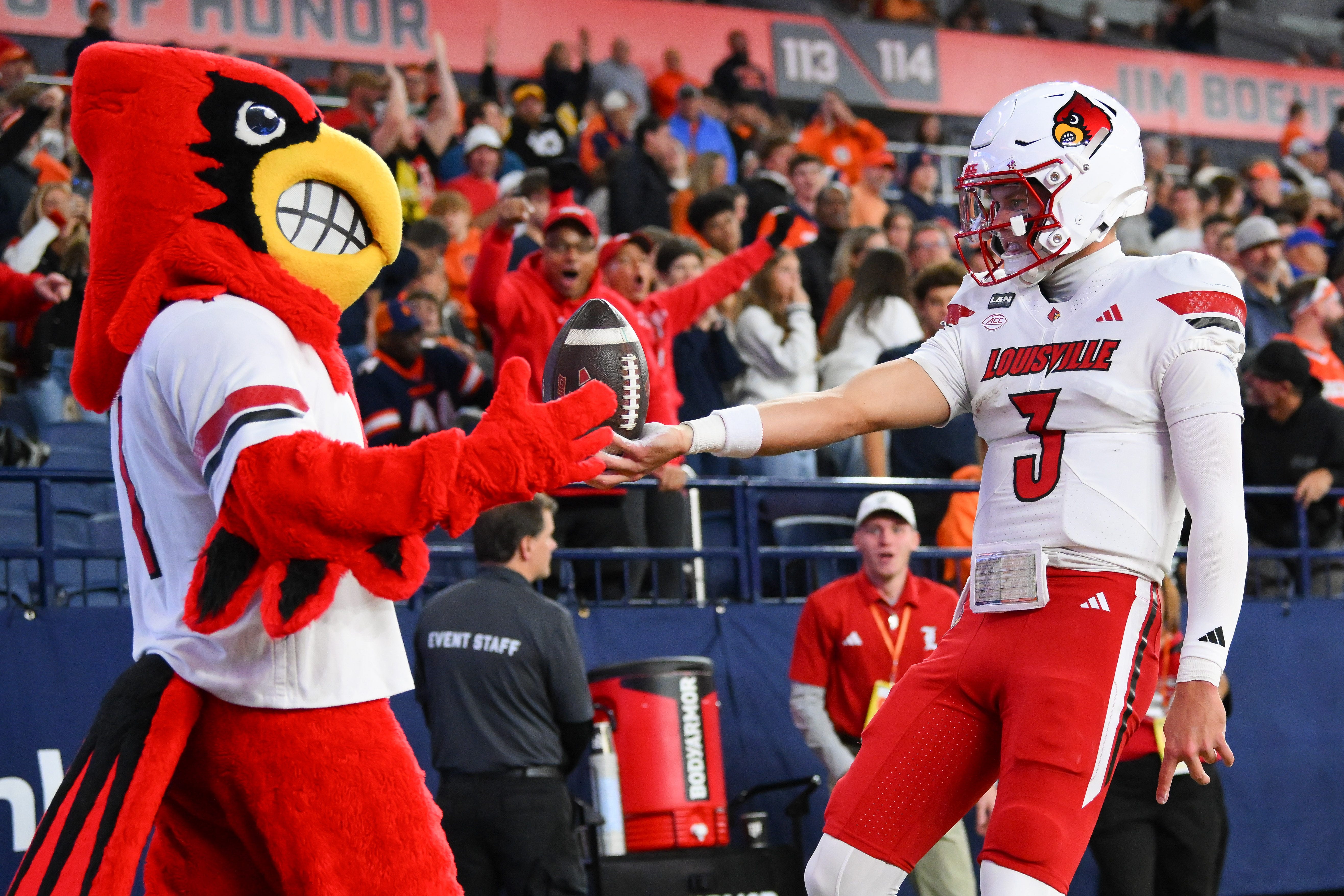 Oct 17, 2026; Syracuse, New York, USA;  Louisville Cardinals quarterback Lincoln Kienholz (3) celebrates his touchdown run with the Louisville Cardinals mascot during the first half against the Syracuse Orange at the JMA Wireless Dome.  Mandatory Credit: Rich Barnes-Imagn Images