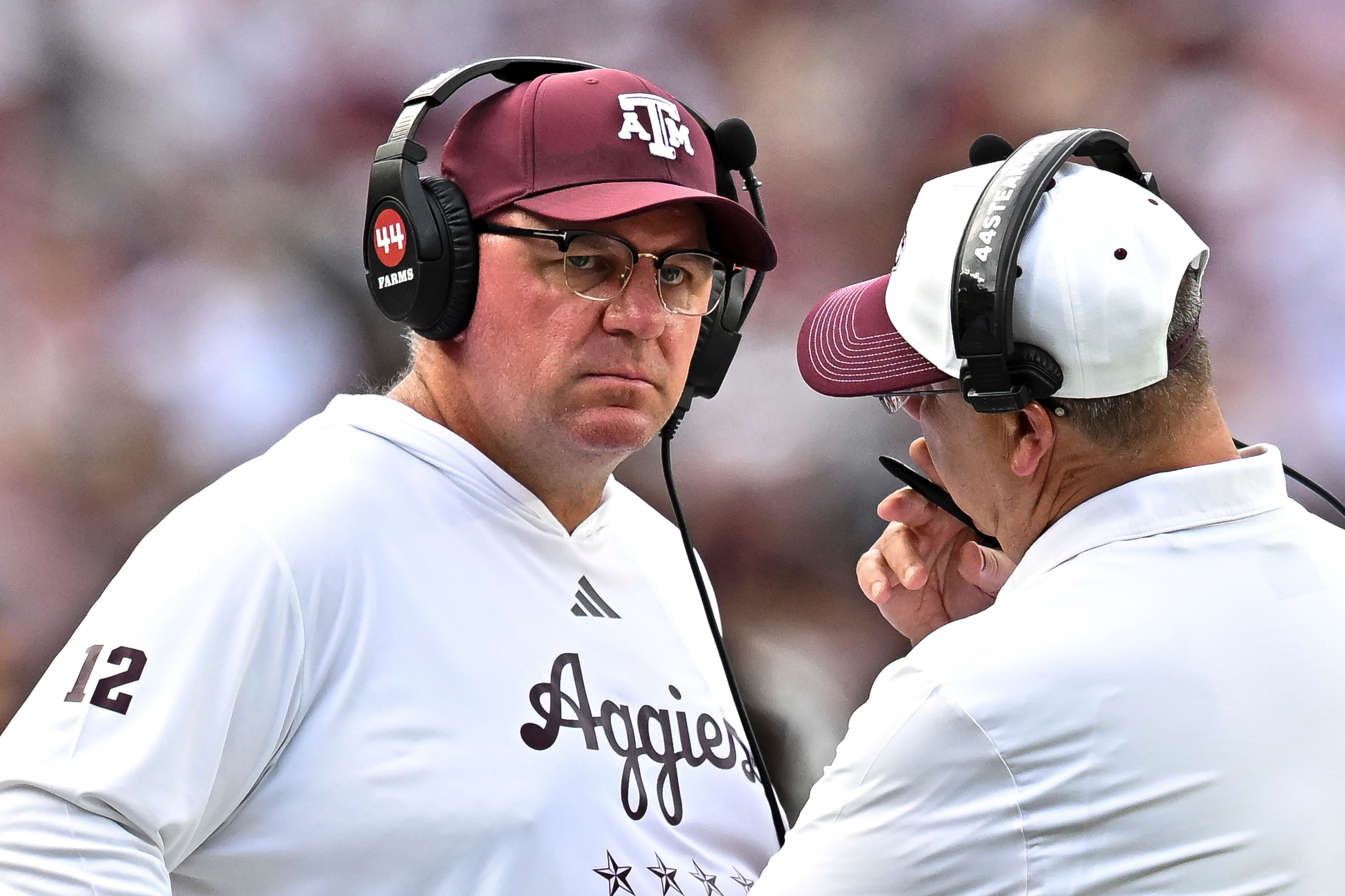 Sep 19, 2026; College Station, Texas, USA;  Texas A&amp;M Aggies head coach Mike Elko speaks with a member of his coaching staff during a time-out in the fourth quarter against the Kentucky Wildcats at Kyle Field. Mandatory Credit: Maria Lysaker-Imagn Images