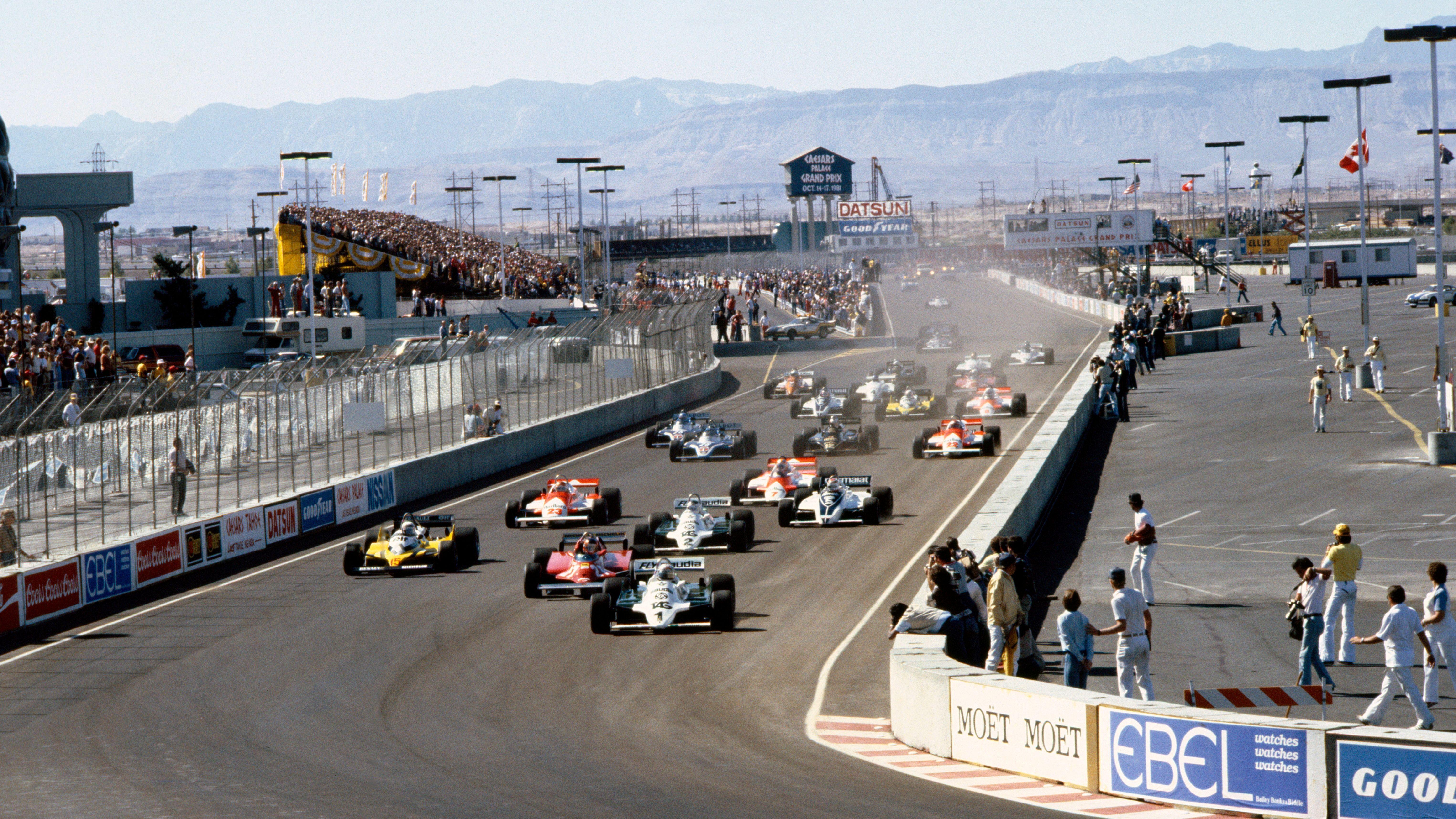 The Williams of Alan Jones leads the field into the first corner of the 1981 Caesars Palace Grand Prix. The mountains of Nevada can be seen in the background