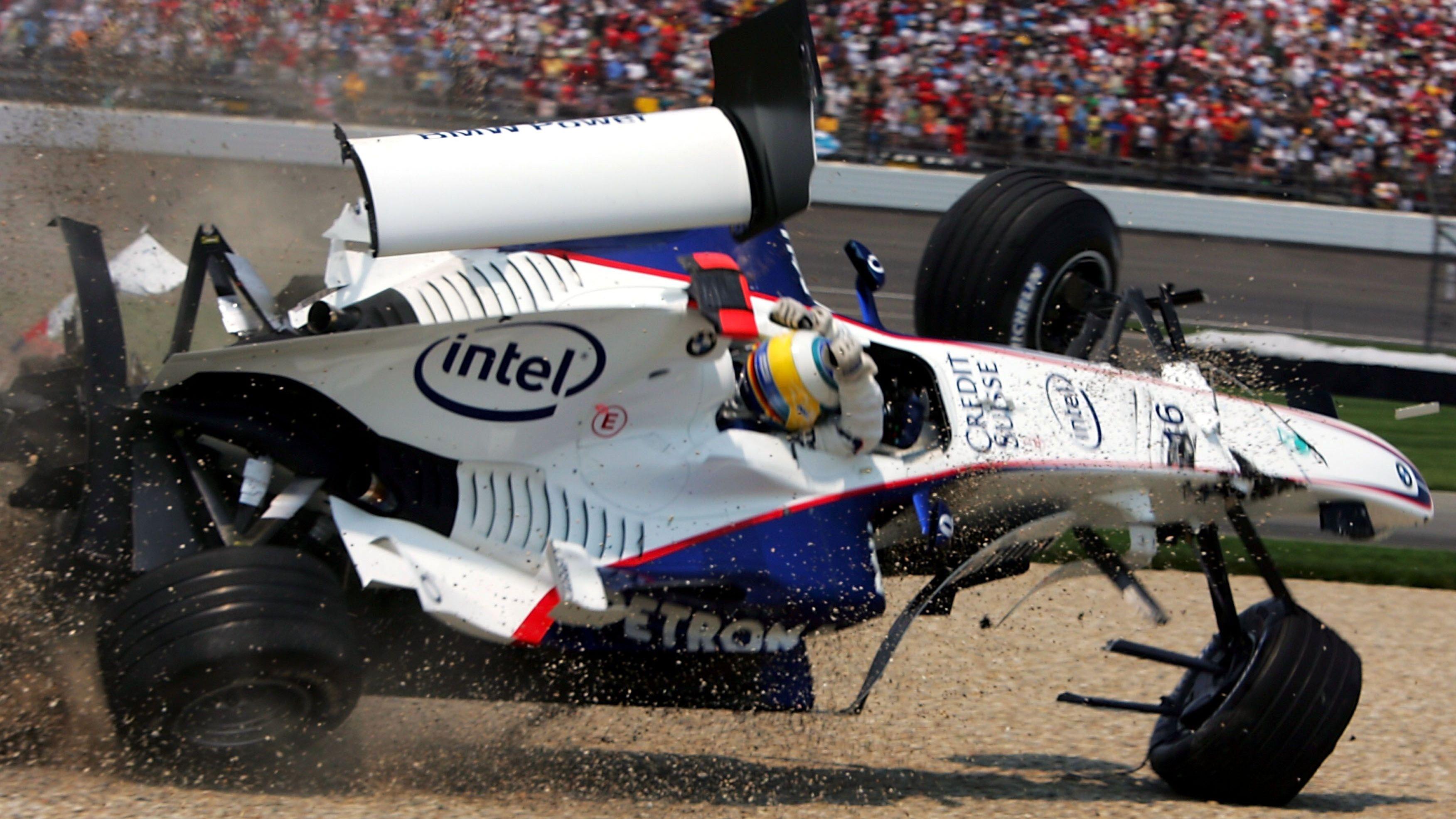 Nick Heidfeld covers his helmet with his arms and braces for impact as his BMW Sauber barrel-rolls during the 2006 US Grand Prix in Indianapolis
