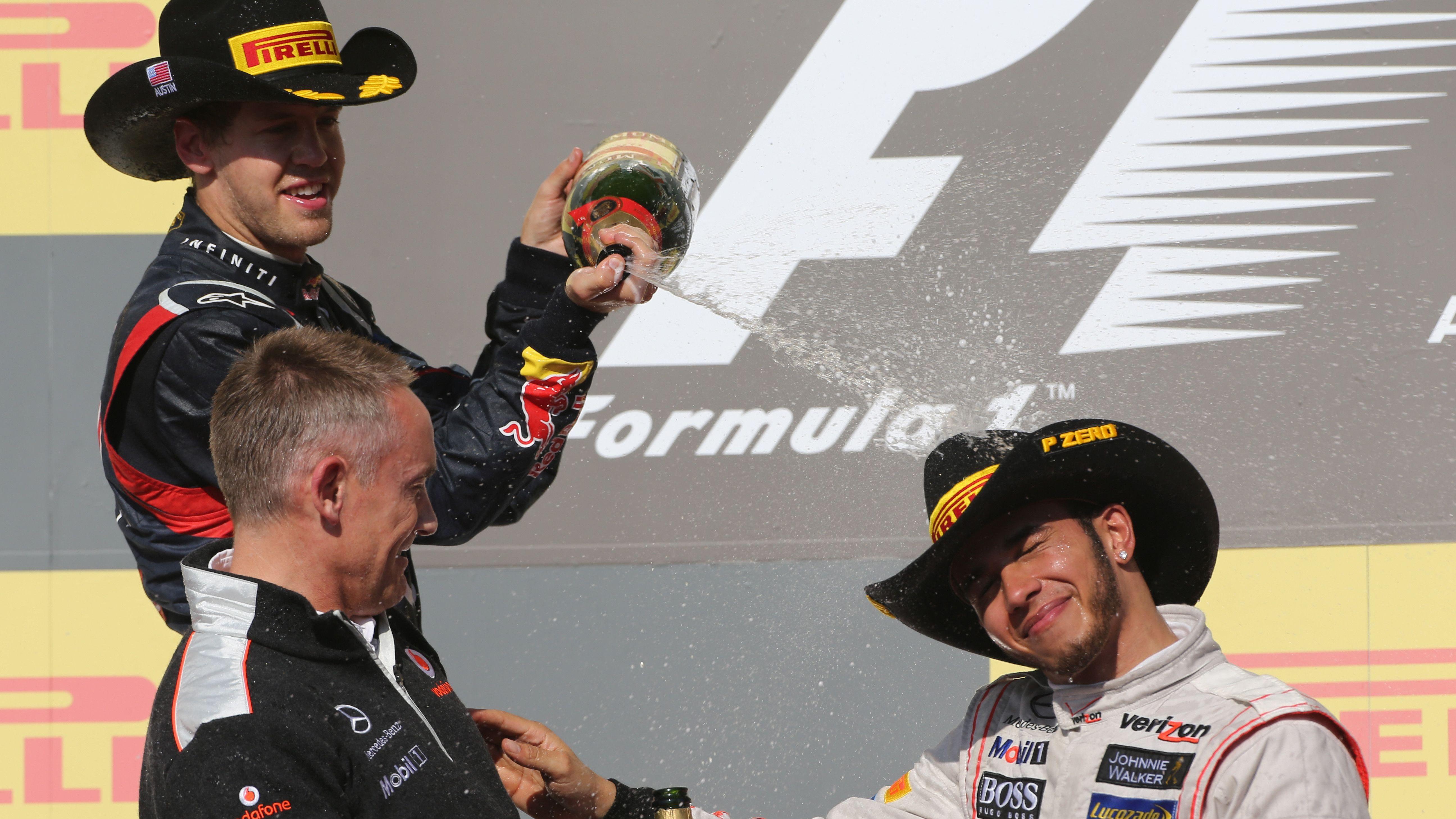 Red Bull's Sebastian Vettel sprays champagne over race winner after the 2012 United States Grand Prix in Austin. Both men are wearing 10-gallon hats, while then McLaren team principal Martin Whitmarsh is stood in front of Vettel