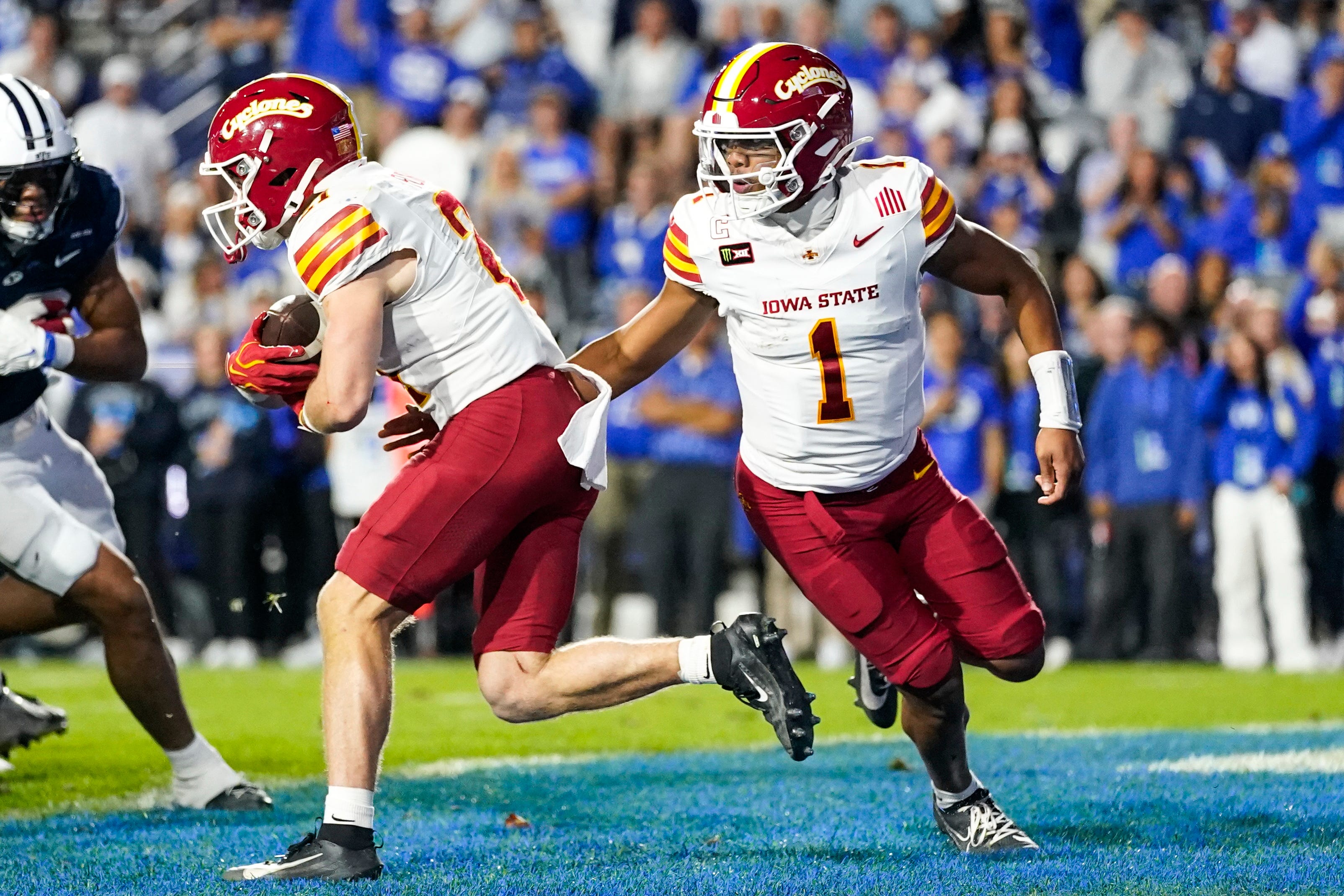 Oct 9, 2026; Provo, Utah, USA; Iowa State Cyclones quarterback Jaylen Raynor (1) Hans the ball off to running back Aiden Flora (21) during the second half at LaVell Edwards Stadium. Mandatory Credit: Aaron Baker-Imagn Images